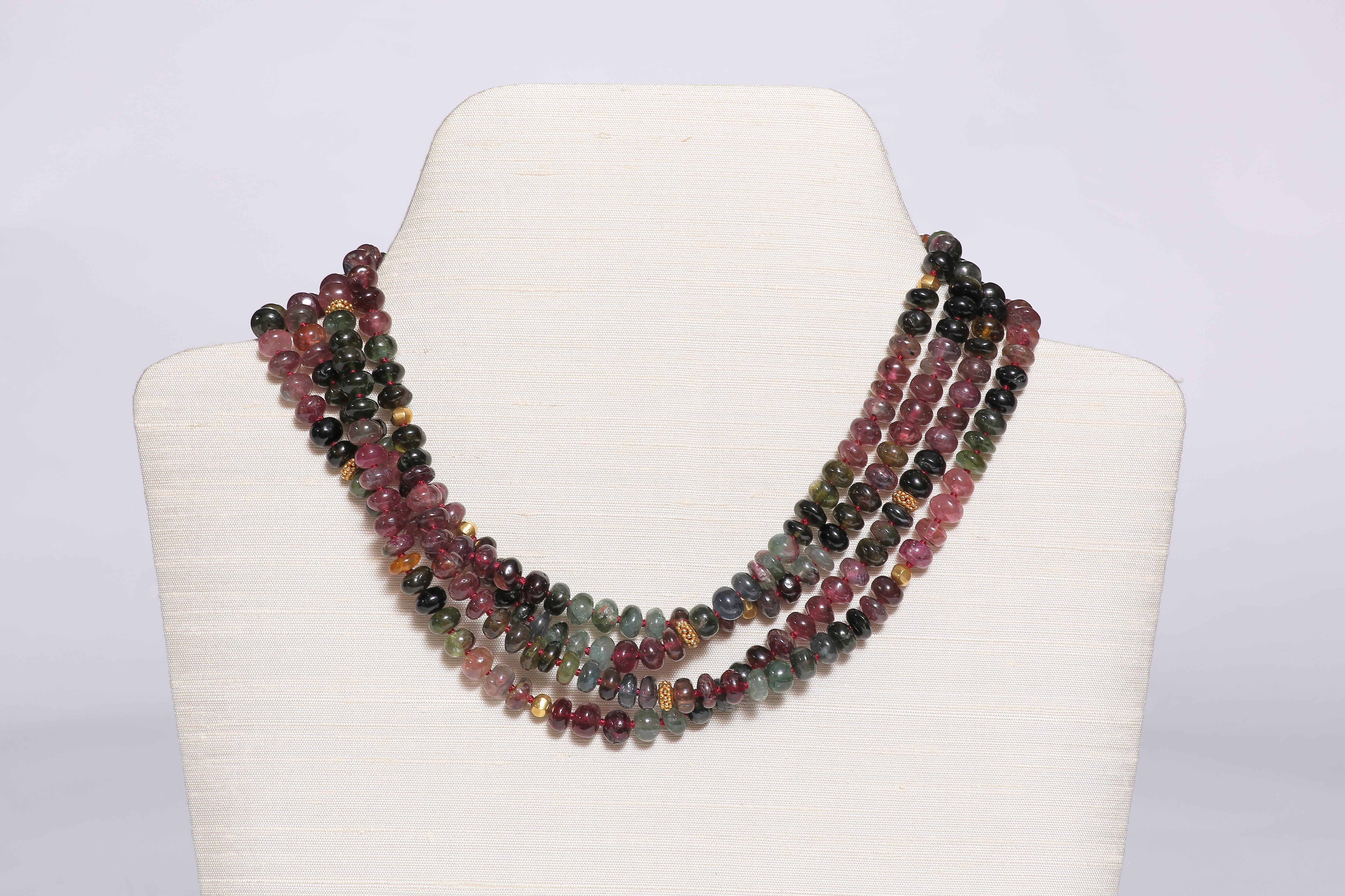 The precious long necklace is formed by 2 strings of wonderfully carved tourmaline beads, spaced with 18k gold beads. The 33