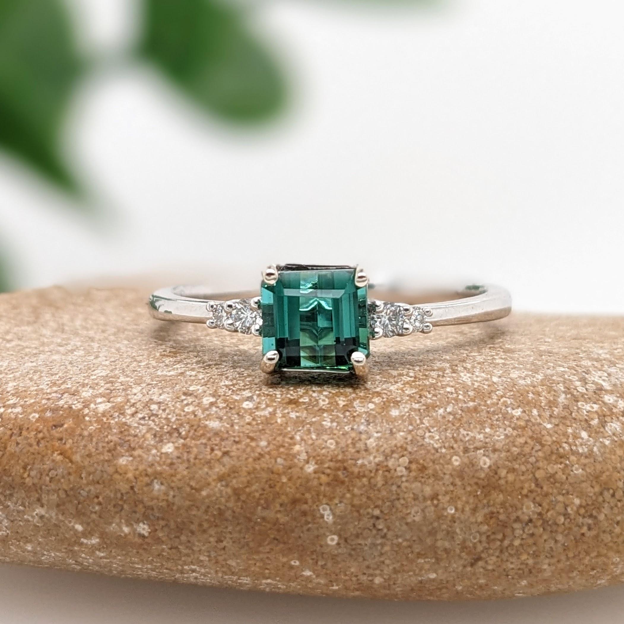 A vivid green Tourmaline looks exquisite in this elegant minimalist ring with cute round diamond accents. A statement ring design perfect for an eye catching engagement or anniversary. This ring also makes a beautiful October birthstone ring for