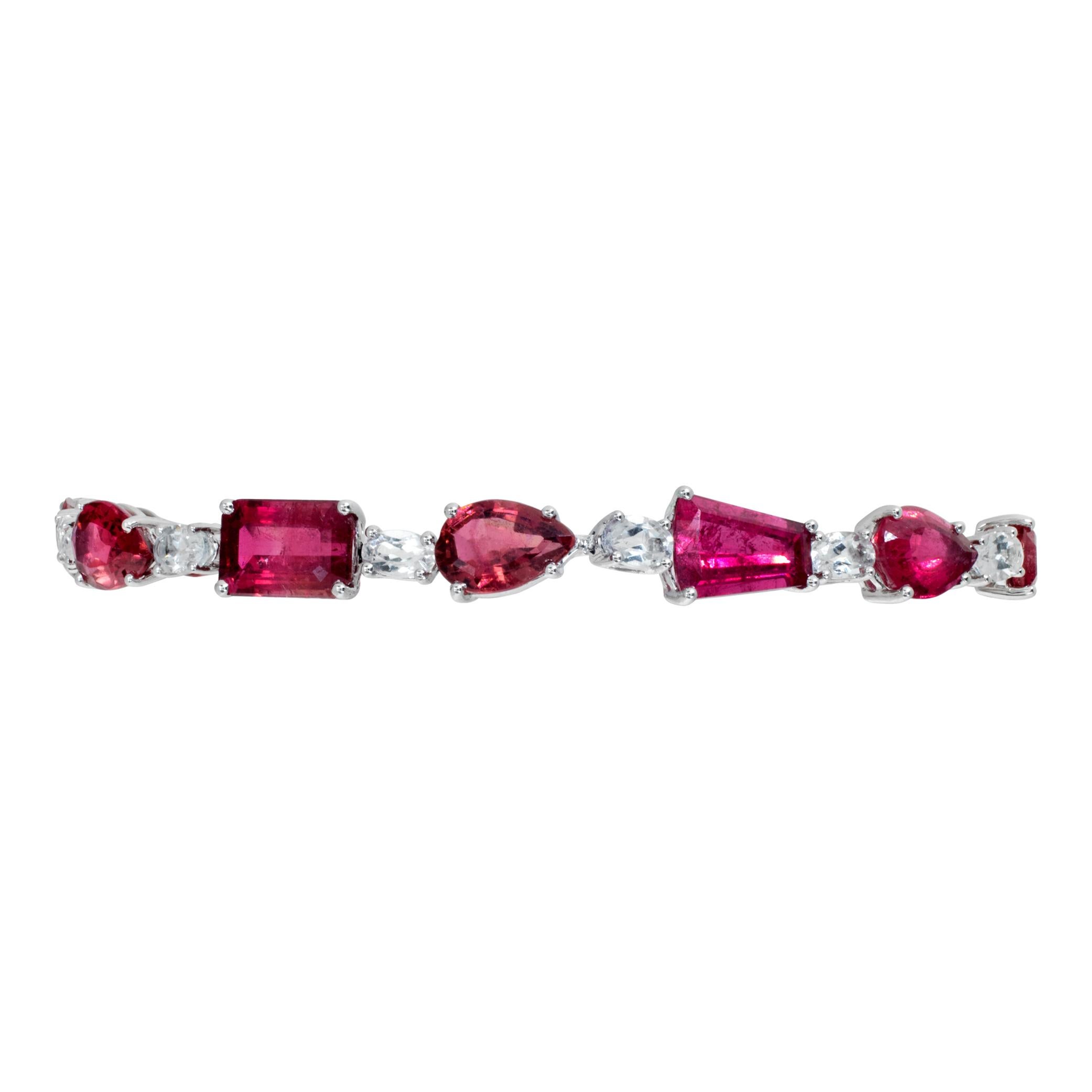 Stunning 18k white gold bracelet with 15.51 carats in emerald cut, pear cut, round cut, and trapezoid cut pink tourmaline & 4.01 carats in oval cut white topaz. Length 7 inches, width 7mm.