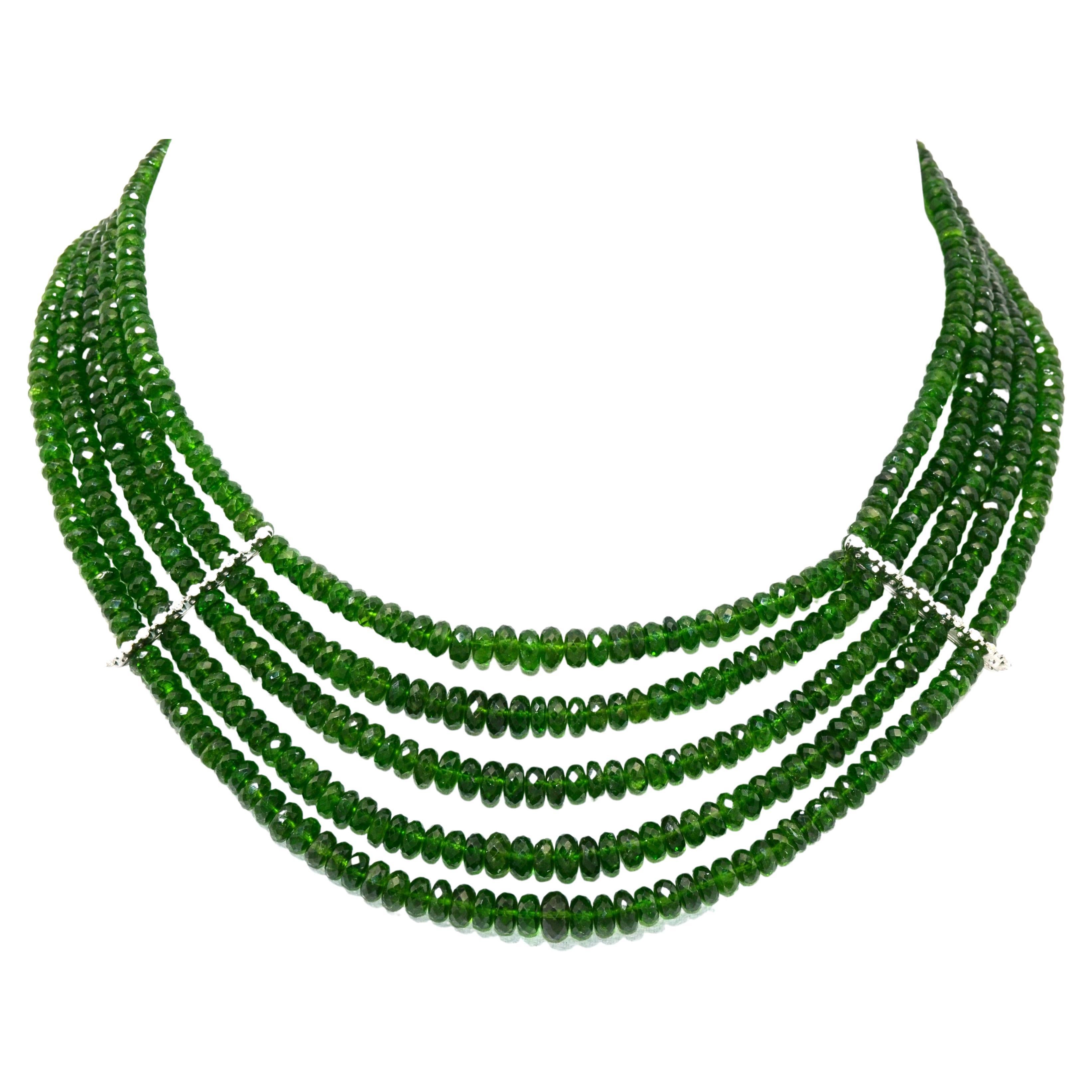 Sparkling natural vivid green tourmalines necklace, made of 5 strands of faceted round degradé beads.
Detailed by a line of diamonds, set on white gold, one each side of the necklace.
Same style clasp decorated by diamonds and a short tassel of