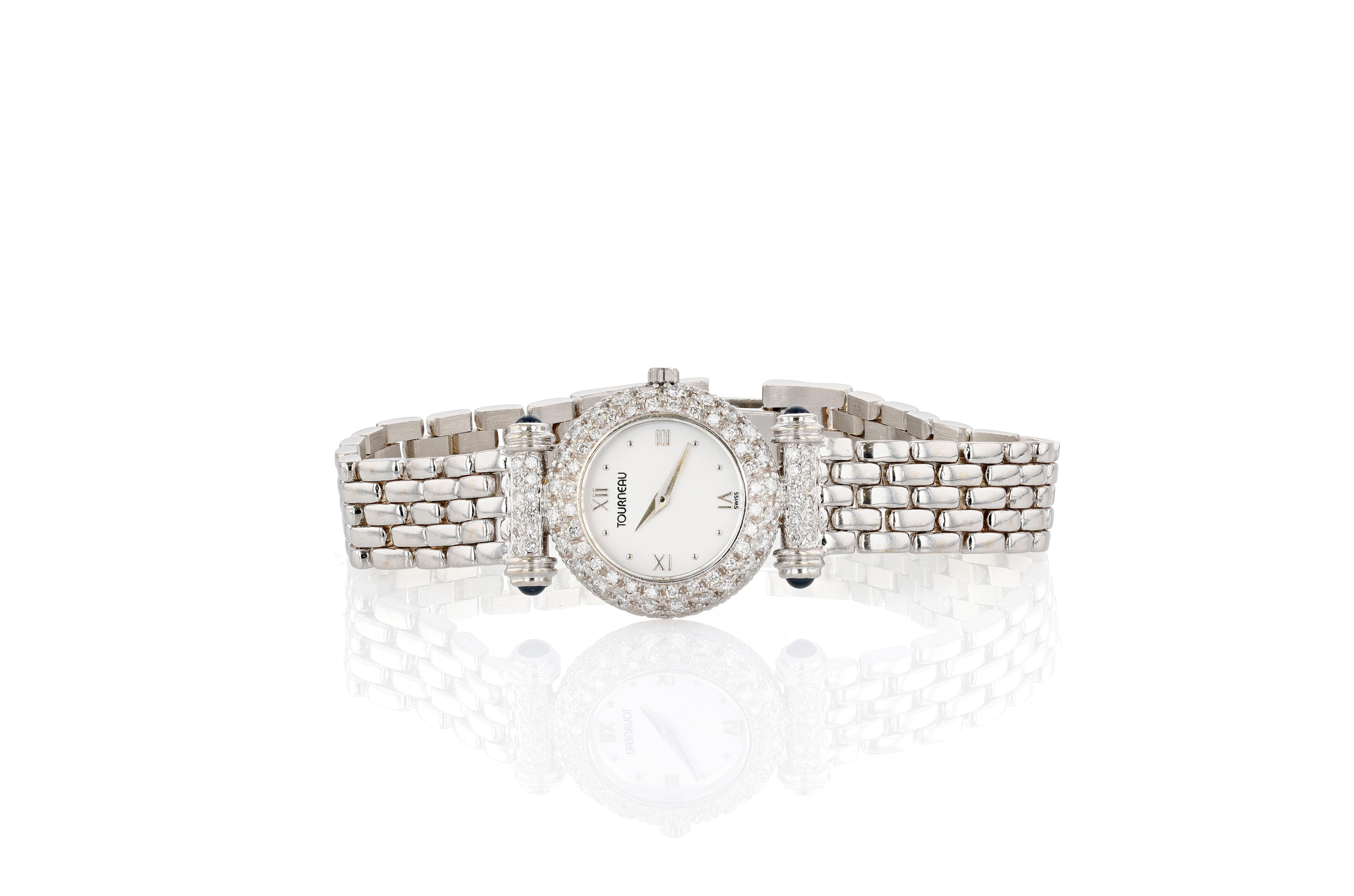 Eine zierliche, sehr tragbare Armbanduhr aus 14 Karat Weißgold, Diamanten, Saphiren und Perlmutt aus der geschätzten Manufaktur Tourneau. Die Quarz-Armbanduhr hat ein rundes 24-mm-Gehäuse, das vollständig mit Diamanten besetzt ist. Die Bandanstöße