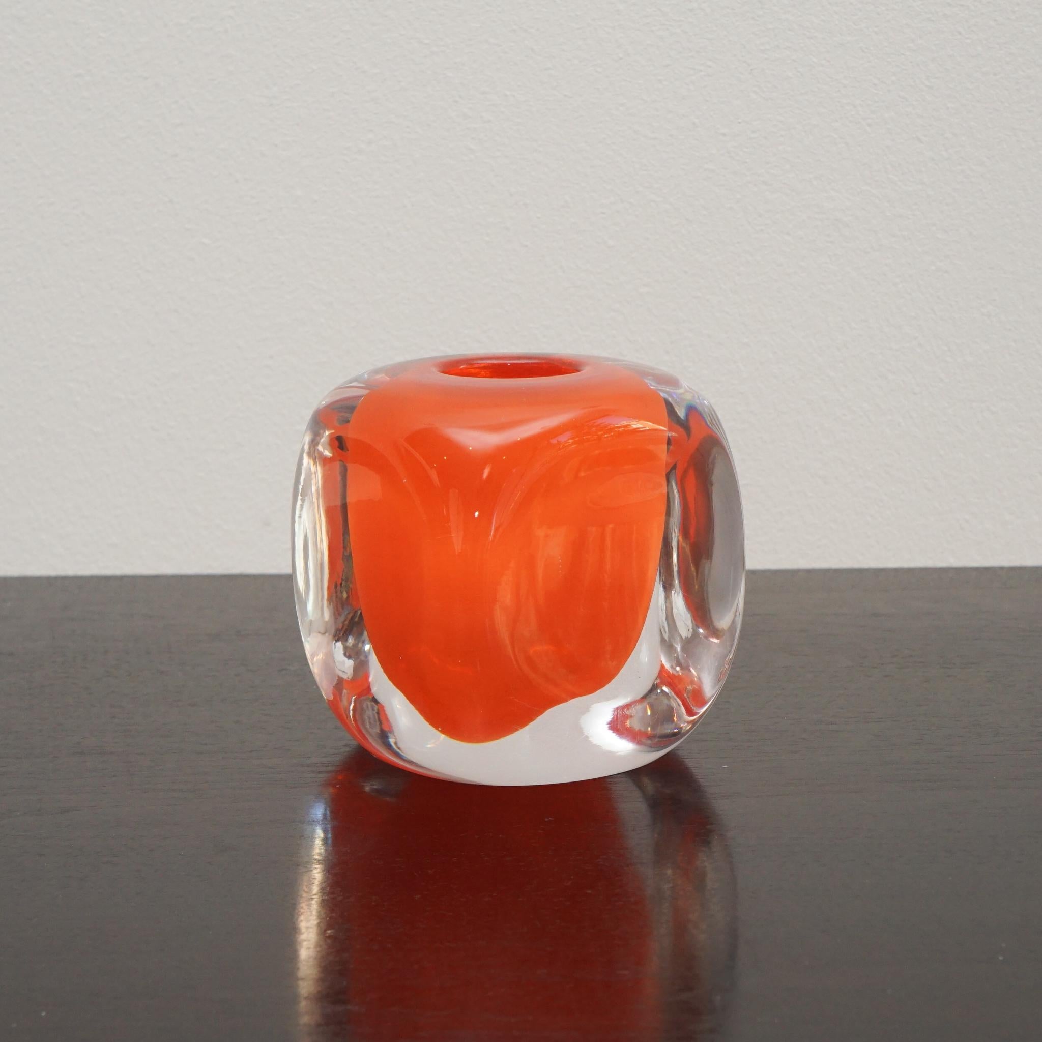 Der belgische Glasmacher Henry Dean stellt seit dreißig Jahren handgefertigte, mundgeblasene Glasgefäße her.  Der hier gezeigte Tournon-Kerzenhalter aus orangefarbenem Klarglas zeigt die Kunstfertigkeit, für die das Unternehmen bekannt ist.  
