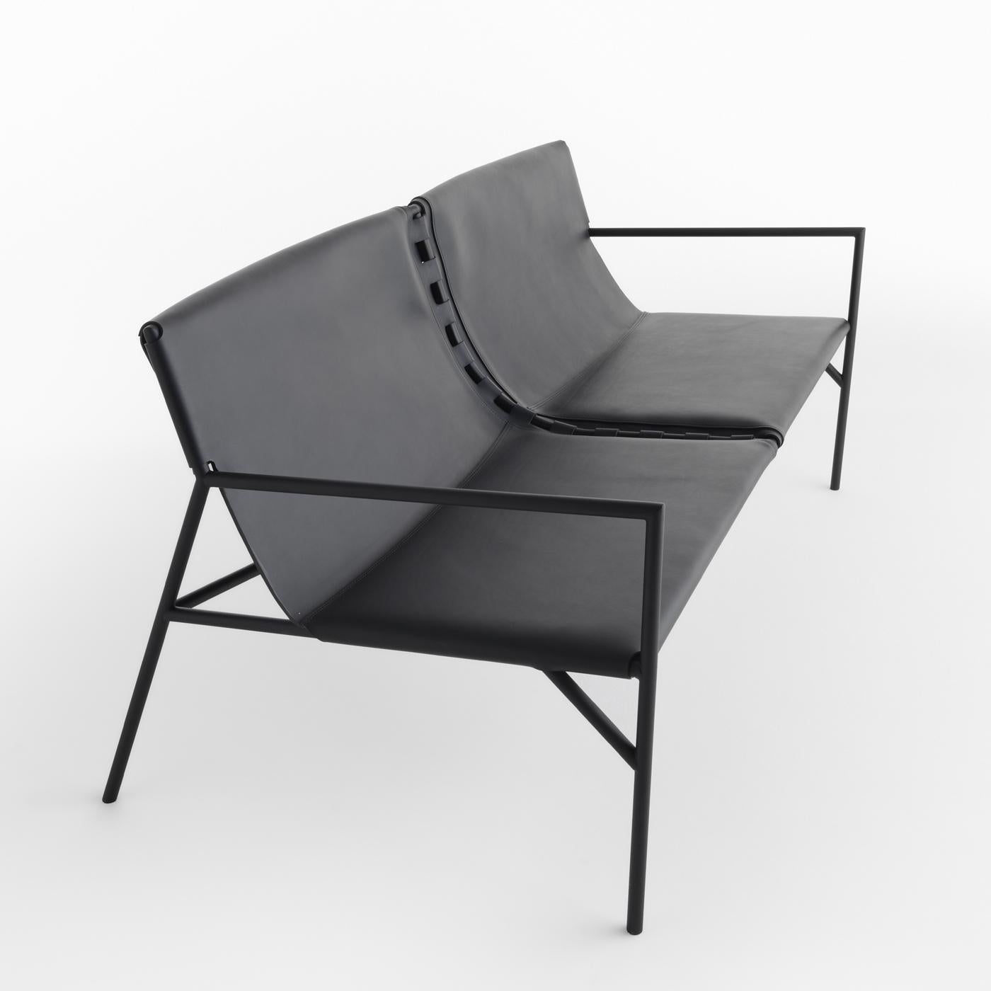 A slim and elegant sofa by Marc Thorpe, this piece combines a solid structure with refined materials for a sophisticated character. A simple and minimal design, it comprises a black metal structure with tubular legs and armrests, and a fine