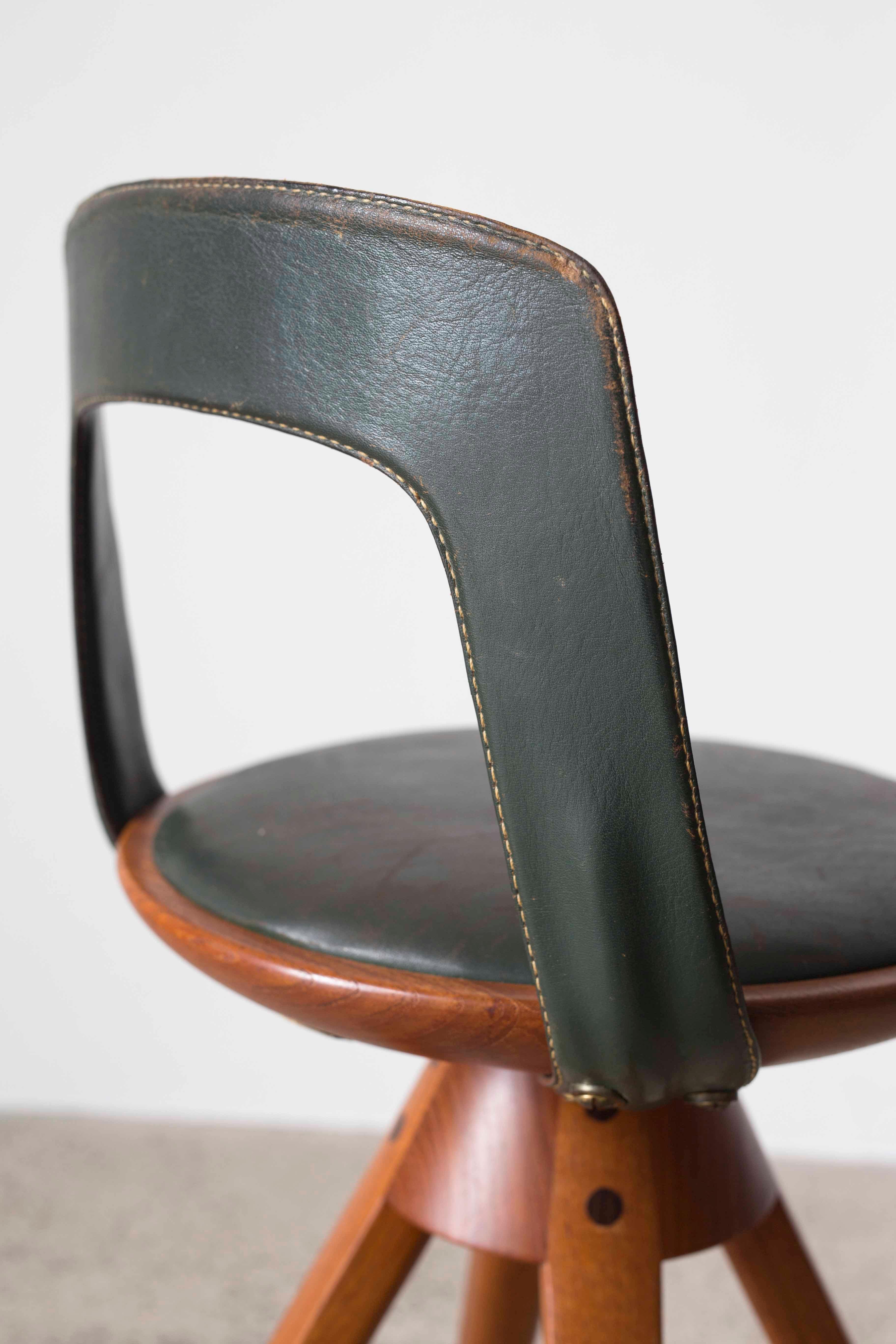 Tove & Edvard Kindt-Larsen swivel stool in teak and original dark green leather. Designed 1957, manufactured and marked by cabinetmaker Thorald Madsen, Copenhagen. 

