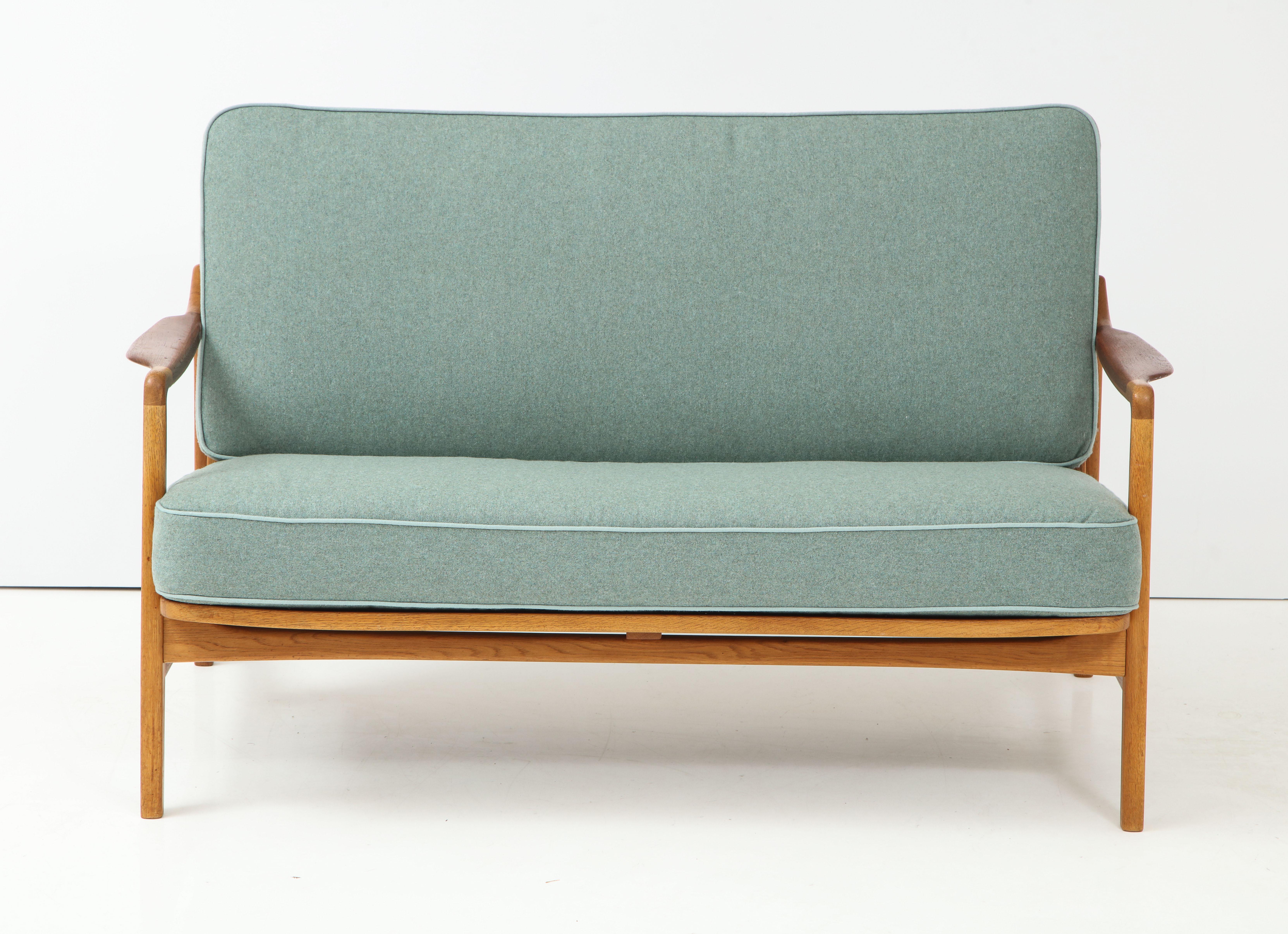 A Danish design teak and oak two person settee, Designed by Tove and Edvard Kindt-Larsen, circa 1950s, Model 117. Settee can be disassembled without the use of tools. Re-upholstered in wool upholstery. Nice patina.
   