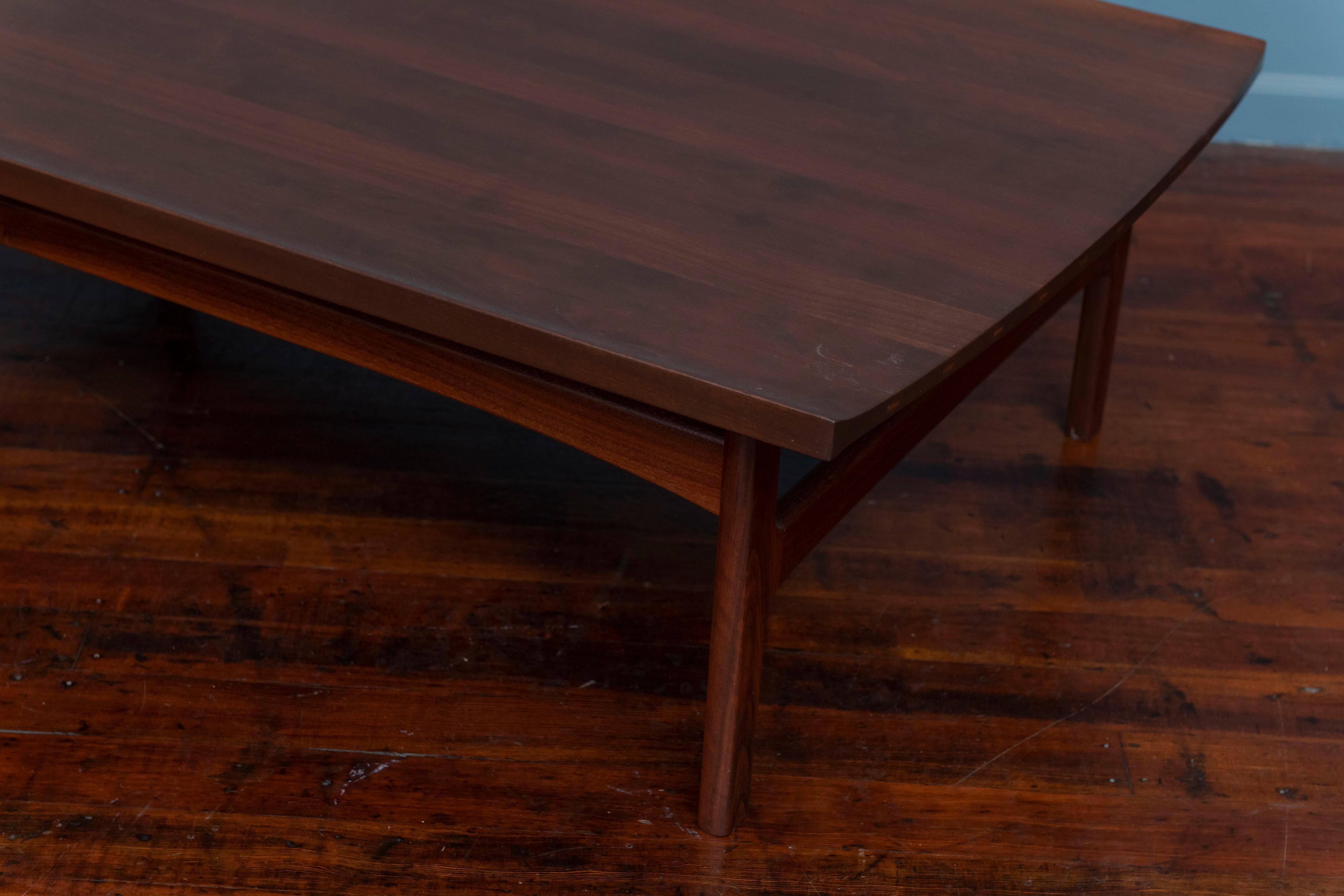 Stunning detailed solid teak Swedish coffee table featuring sculptural lipped edge top with two elegantly curved sides. Exposed wood joinery on the curved edges feature distinctive inlays in lighter, contrasting wood. 
Newly refinished in a dark