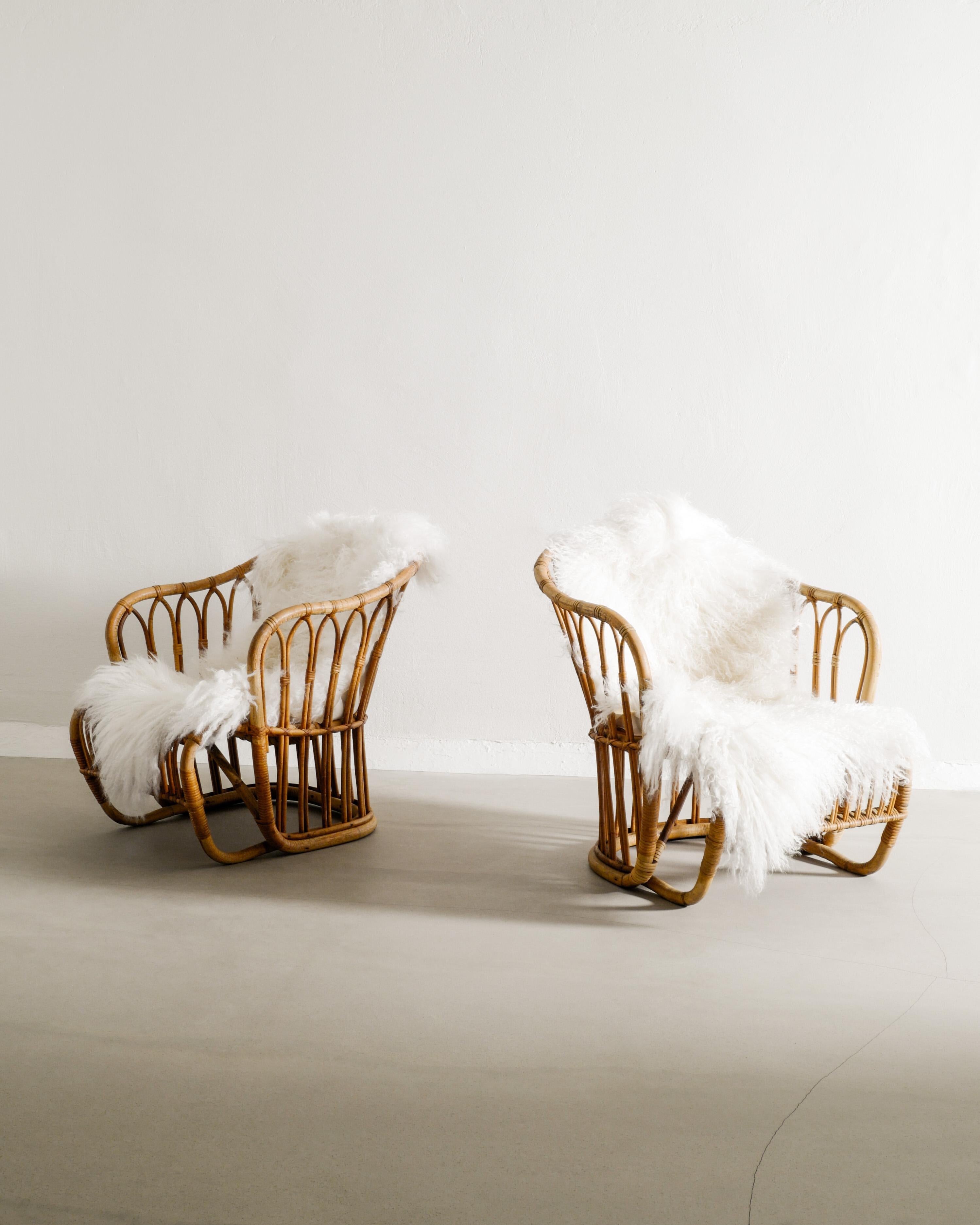 Rare pair of Danish mid century armchairs in rattan produced R. Wengler in Copenhagen Denmark, 1940s. In good original condition with the original brass plates still attached. 

Dimensions: H: 63 cm / 24.80