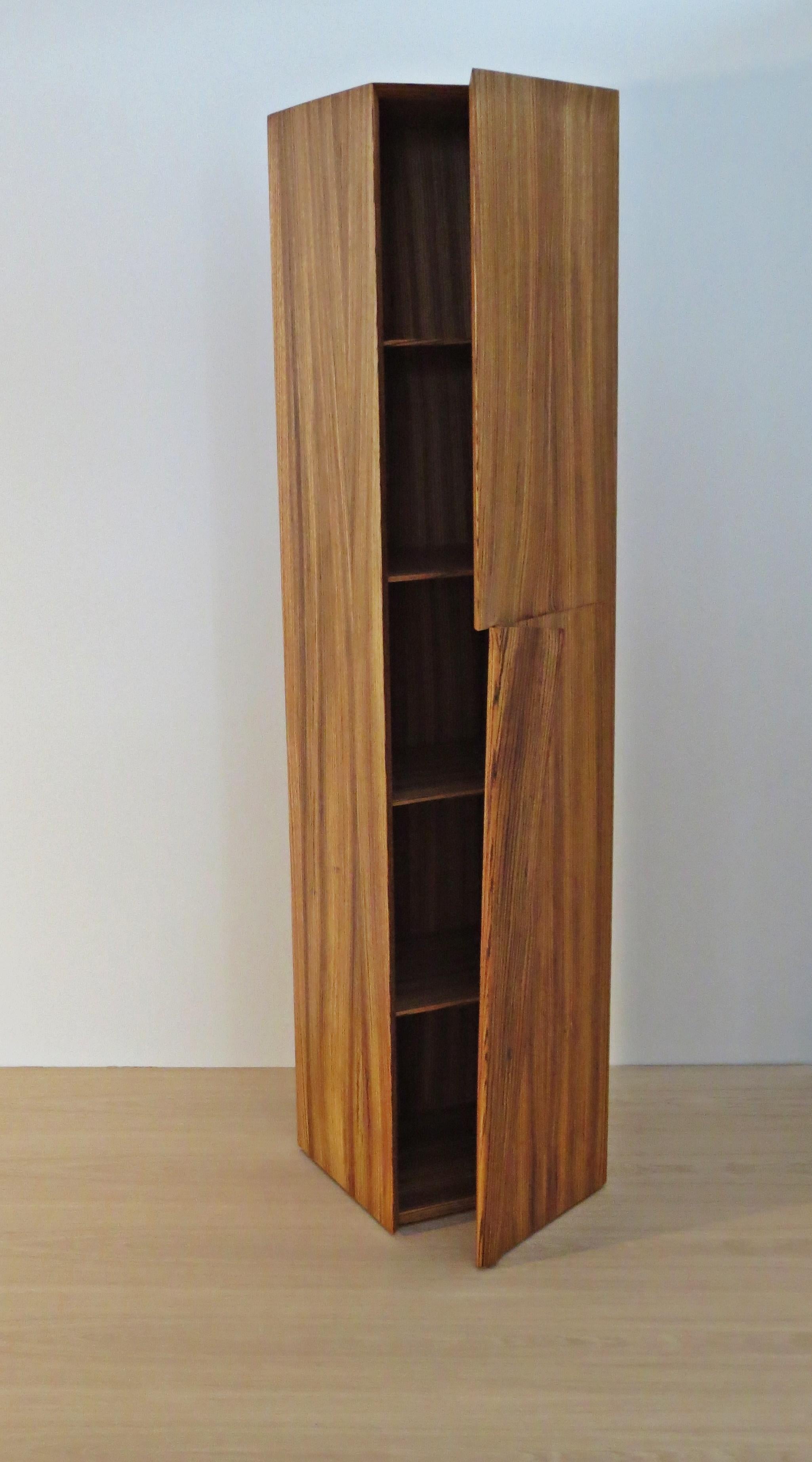 Tall cabinet handmade from solid Zebrano (African Zebrawood).
Created by the German furniture maker and sculptor Eckehard Weimann.

The modern rectilinear body is broken by the grip:
this is sculpted, folded like a dog's ear, folded.

Single