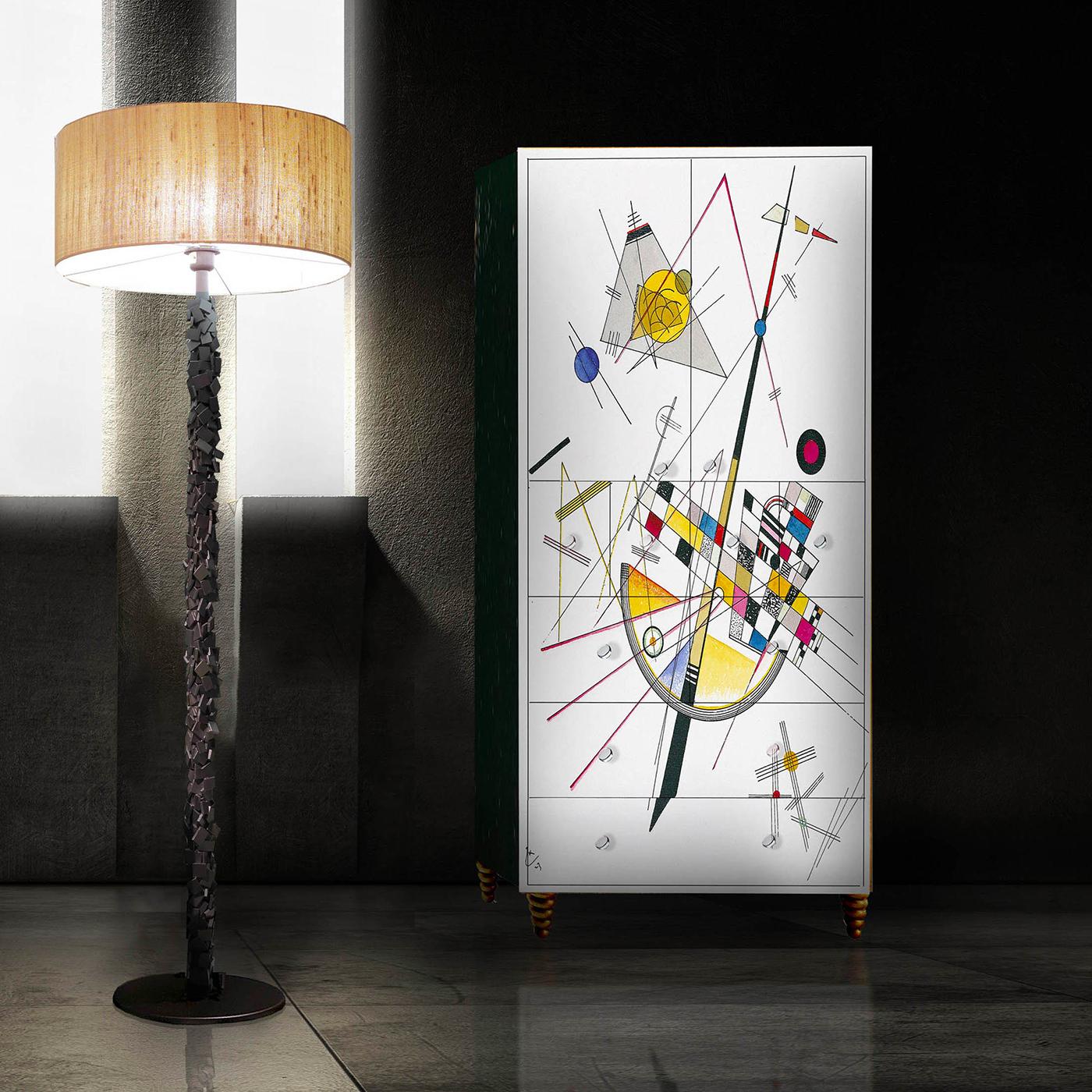 This unique cupboard is a true work of art. Its bold and elegant front decoration is inspired by the dynamic geometries by Kandinsky and painted entirely by hand. The rectangular wooden structure rests on four conical feet with striking grooves, and