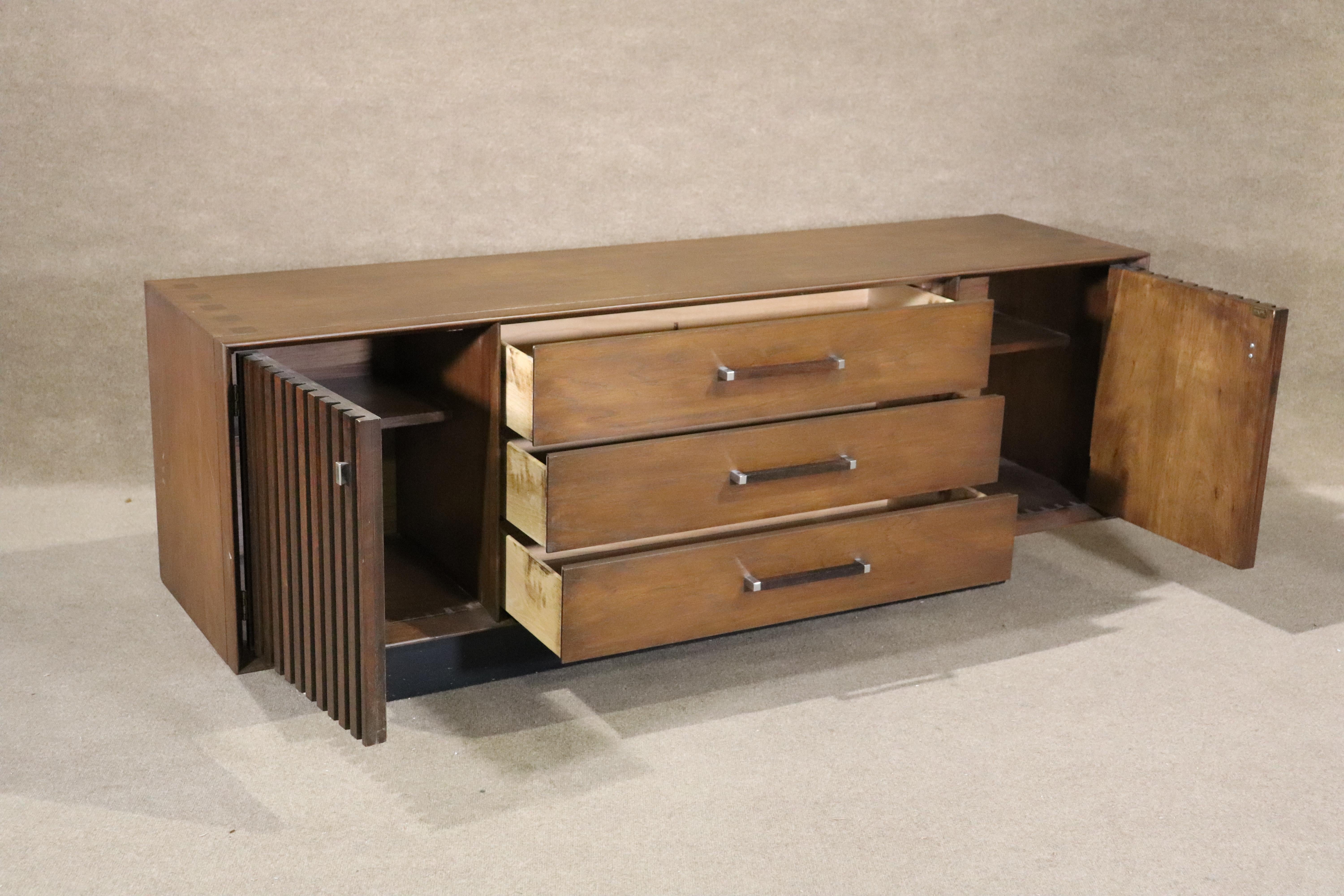 Diese lange Mid-Century Modern Unit hat Kommode Schubladen und Schränke Lagerung. Nussbaumholz mit akzentuierenden Palisanderleisten und Intarsien auf der Oberseite.
Bitte bestätigen Sie den Standort NY oder NJ