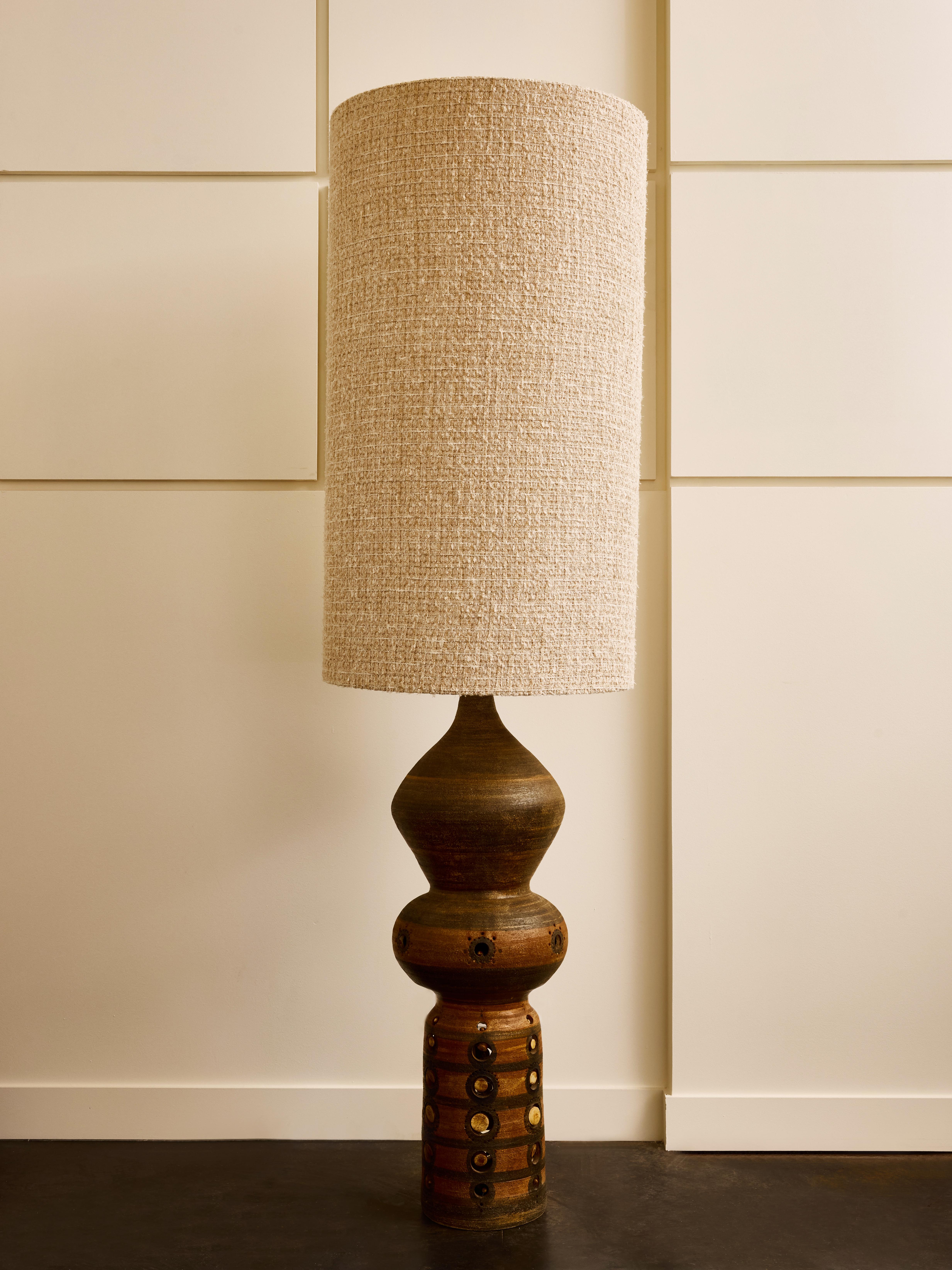 Tall ceramic table lamp by Georges Pelletier featuring his signature early works earth toned mat glazes and decors on steel wires.

The addition of the massive lampshade gives this piece a lofty apparence allowing the piece to be put on a table or
