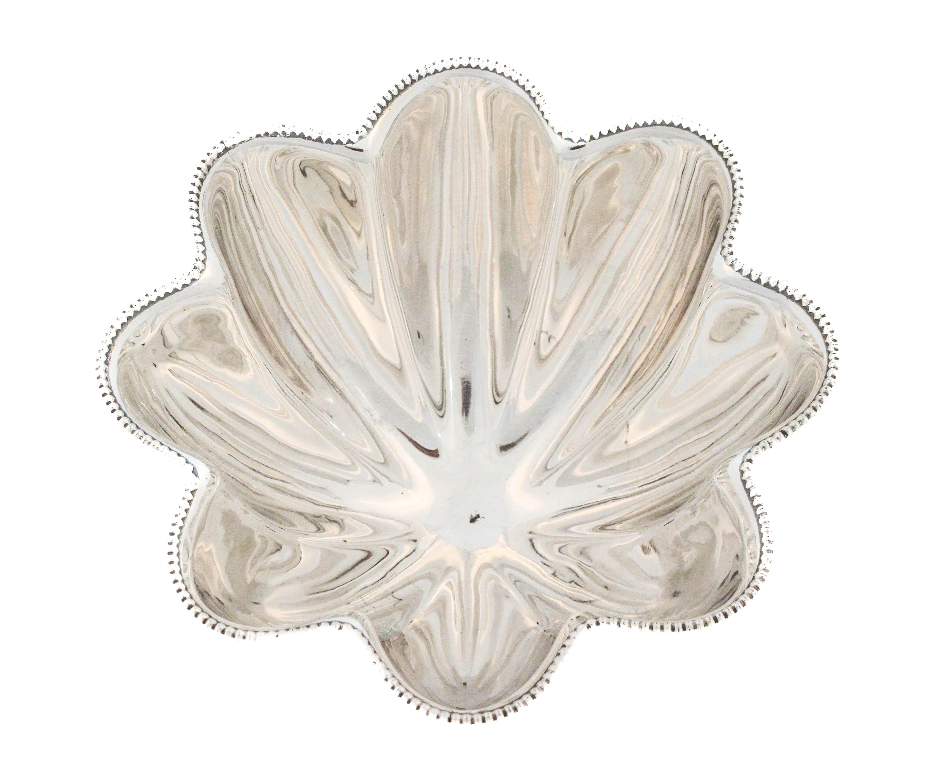 Una raffinata ciotola in argento sterling di Towle Silversmiths, caratterizzata da un'elegante forma smerlata con pannelli scanalati che si irradiano dal centro. La ciotola è rifinita con un bordo di perline che aggiunge un tocco di dettaglio