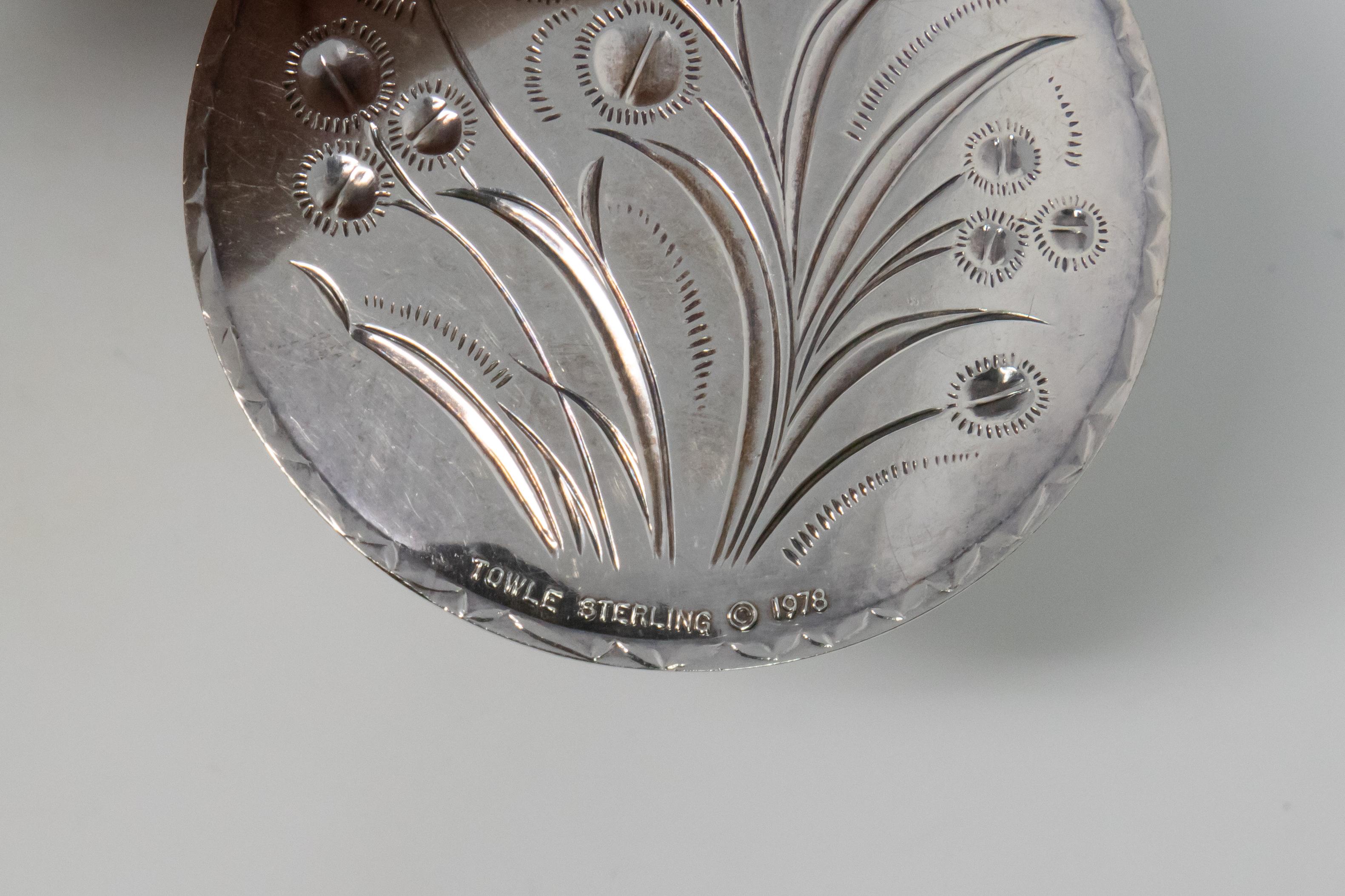 Offering a gorgeous Towle sterling eight maids a milking ornament. The front depicts the 8 maids holding buckets on their shoulders. They have a foliate circle around them and in the middle is a cows head.