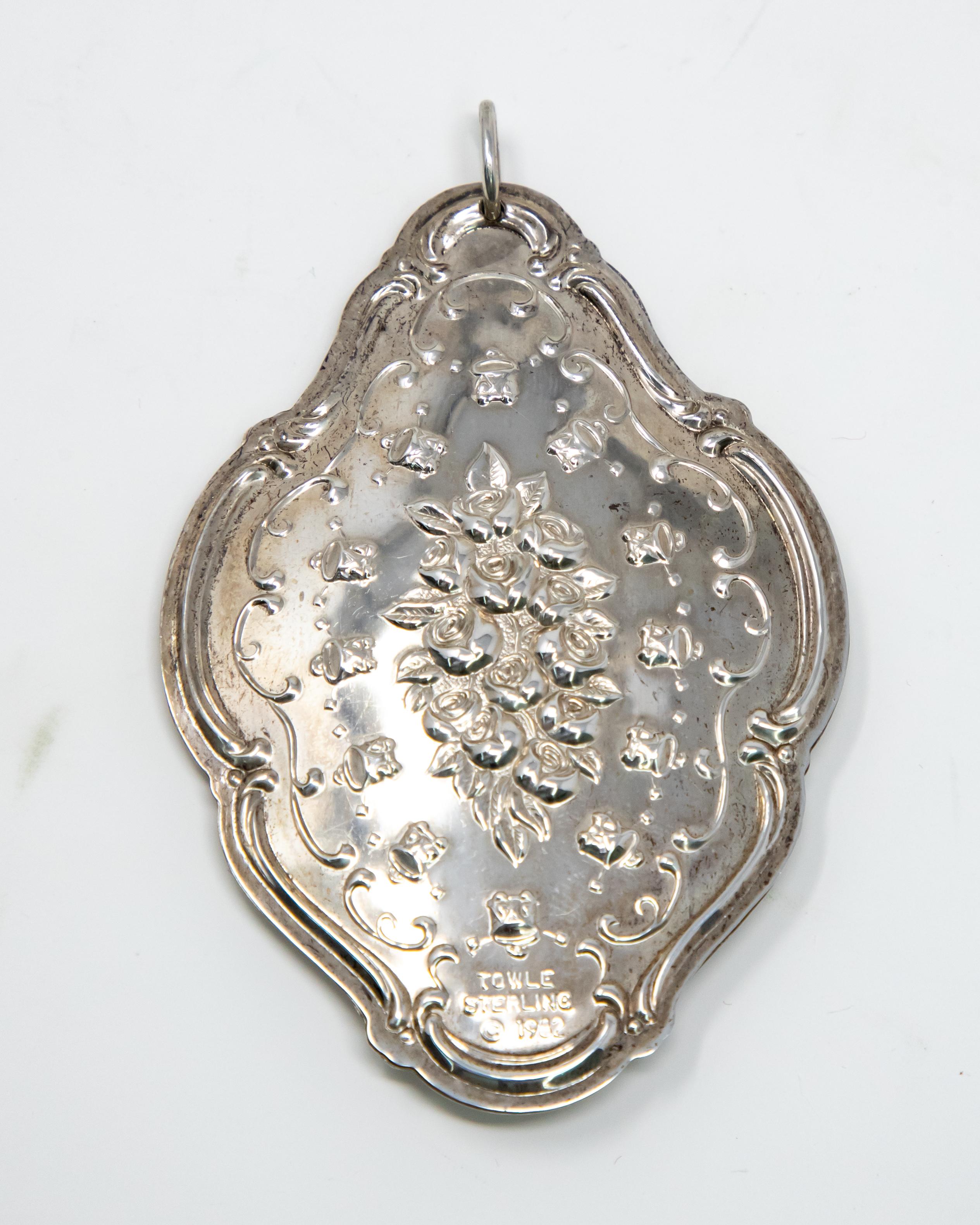 Offering this stunning Towle Sterling twelve drummer drumming ornament. The front depicts a floral and foliate motif. Around that is 12 drums, and scrollwork around them. The back depicts a floral, foliate and scrollwork motif. Marked Towle