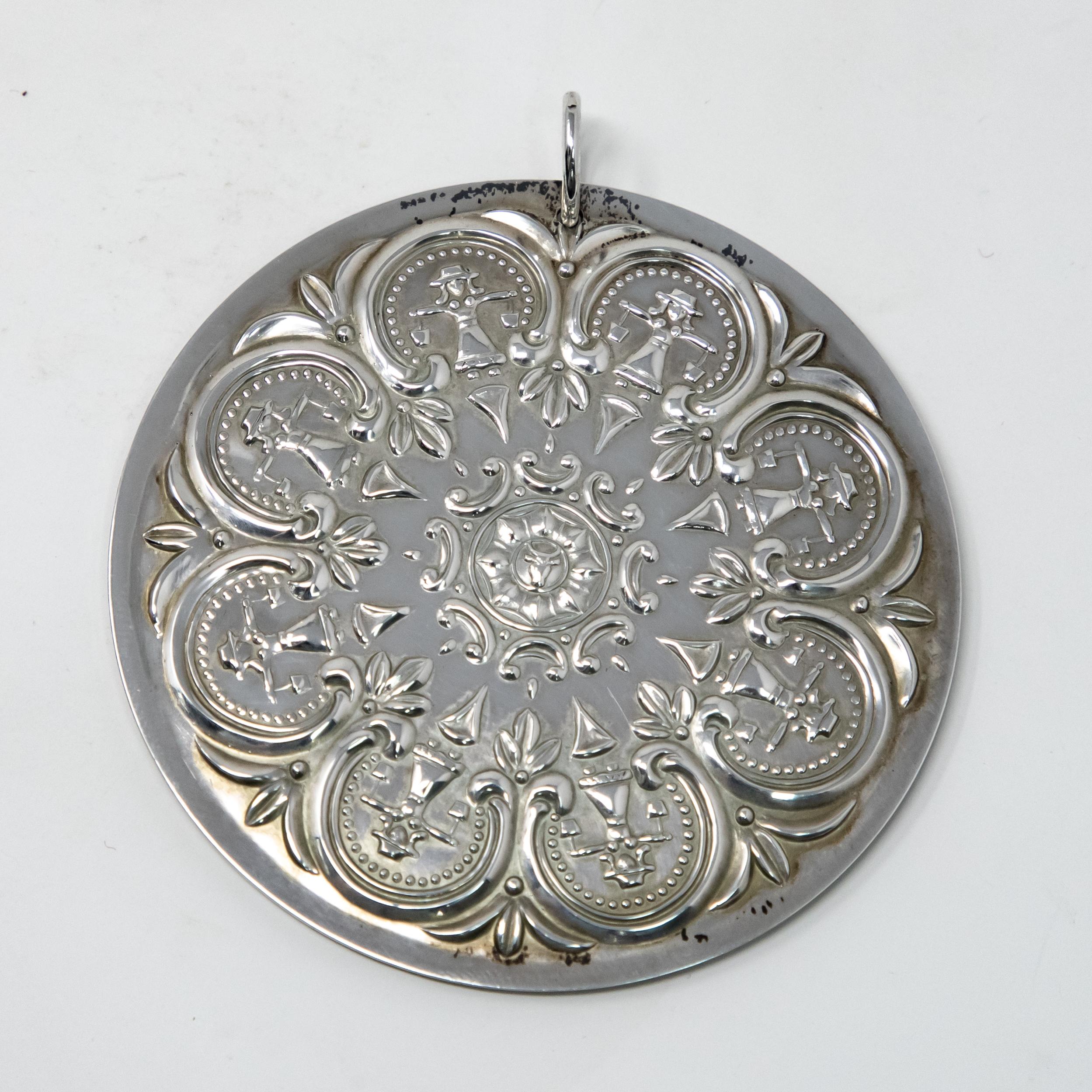 Offering this gorgeous Towle sterling ornament from 1978. It depicts scroll work and foliate designs to the front with eight women holding pails. The back depicts foliate and floral designs. Marked on back with Towle sterling, 1978.