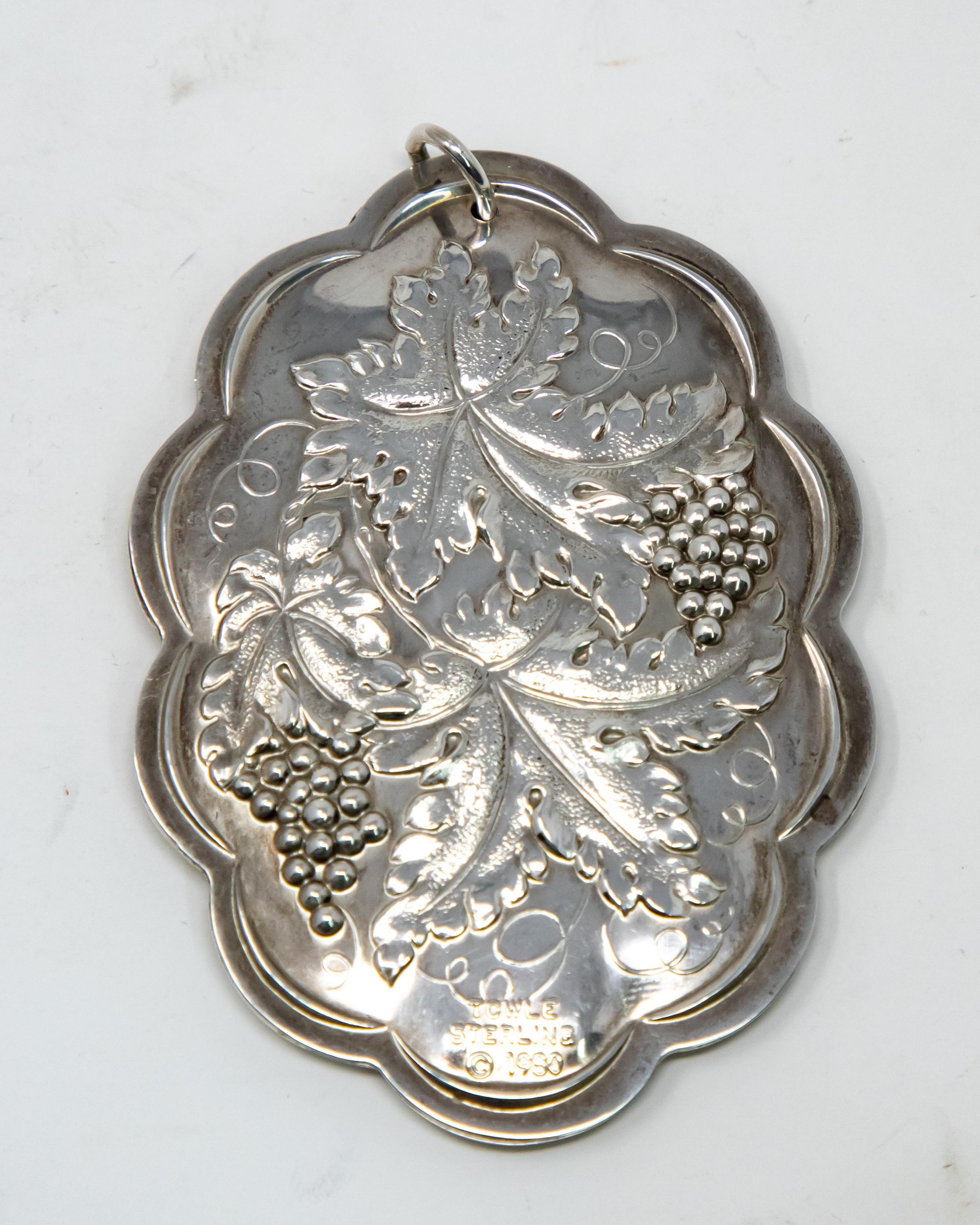 Offering this beautiful Towle sterling ornament from 1980. In an elongated shape the back has floral, foliate and grape motif. Marked Towle Sterling, 1980. The front depicts a center medallion, with Ten Lords a Leaping around it.
