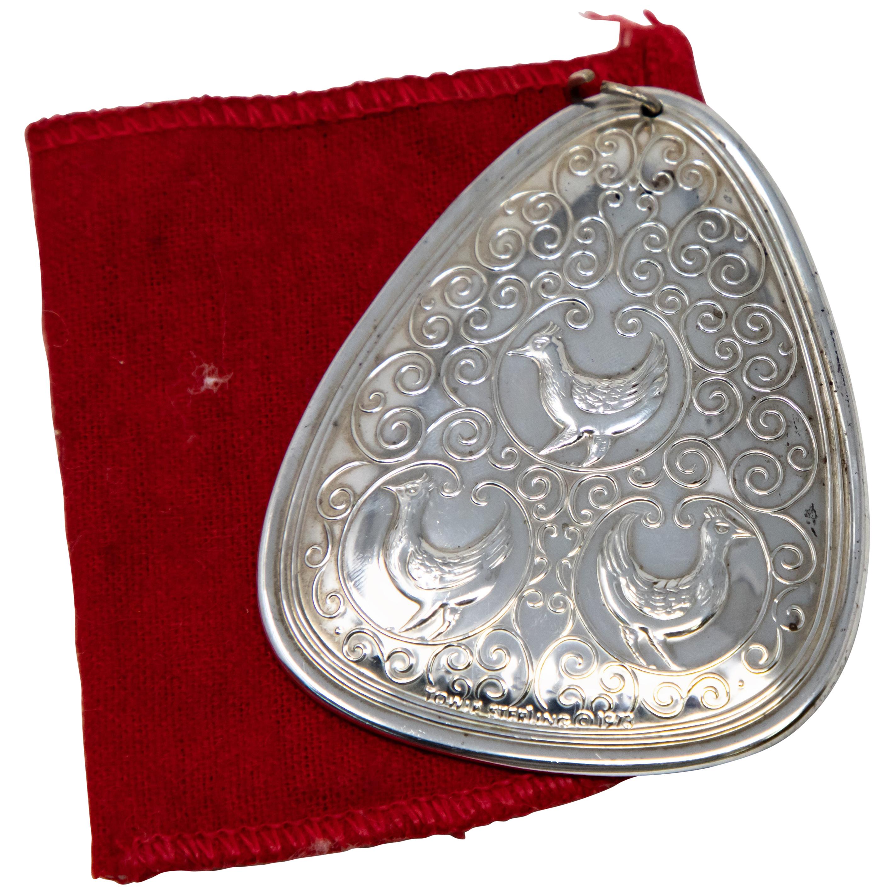 Offering this gorgeous Towle sterling ornament from 1973 with velvet pouch. The front depicts the three French Hens with lots of scrollwork. Marked Towle Sterling, 1973. The back depicts a foliate and floral design.