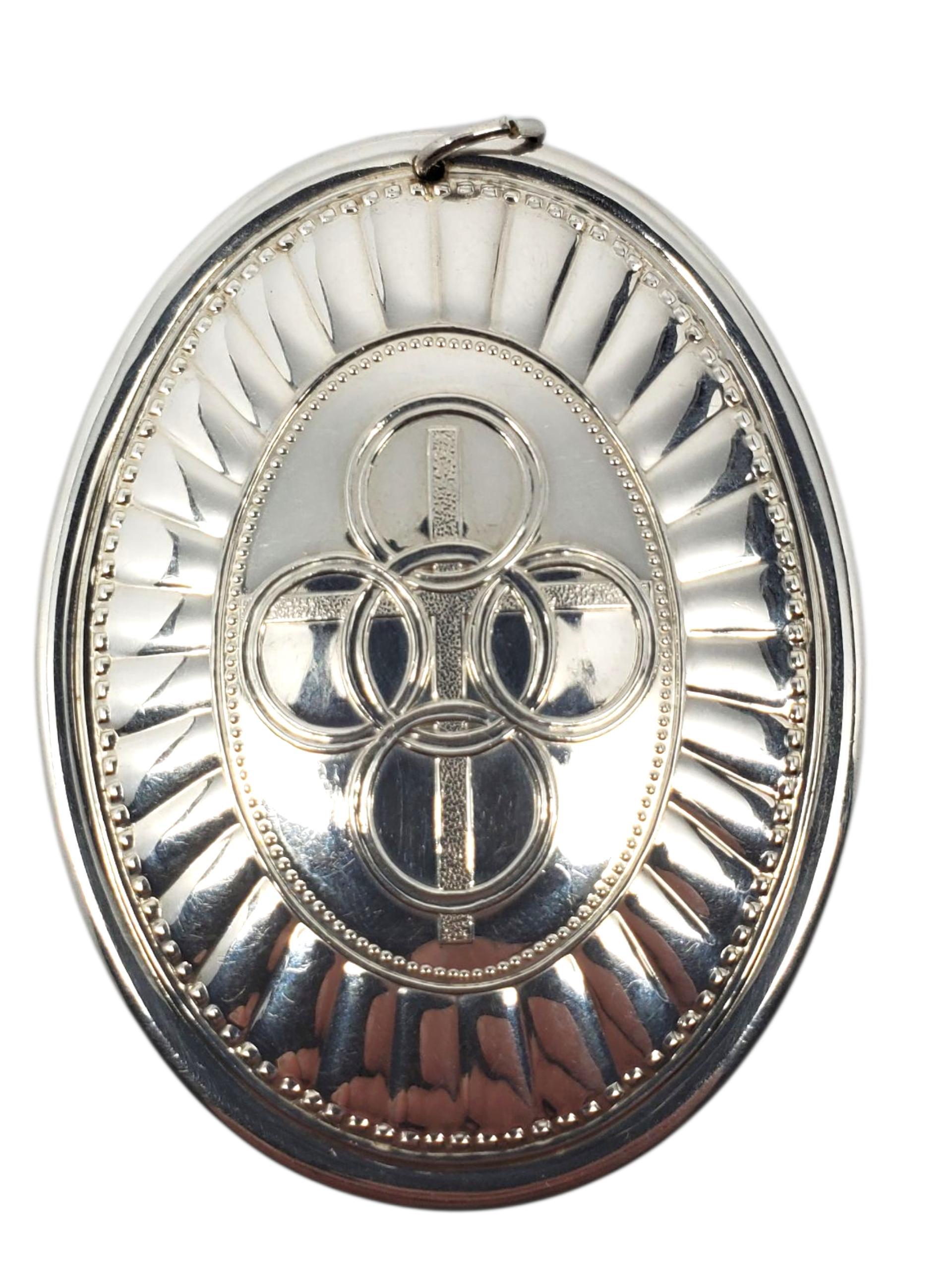 Ornamento di Natale Towle in argento sterling del 1975 - A. Silver

Questo ornamento natalizio vintage in argento sterling del 1975 di Towle presenta un dettagliato motivo floreale e a scacchi su un lato e un radioso disegno a croce e anello