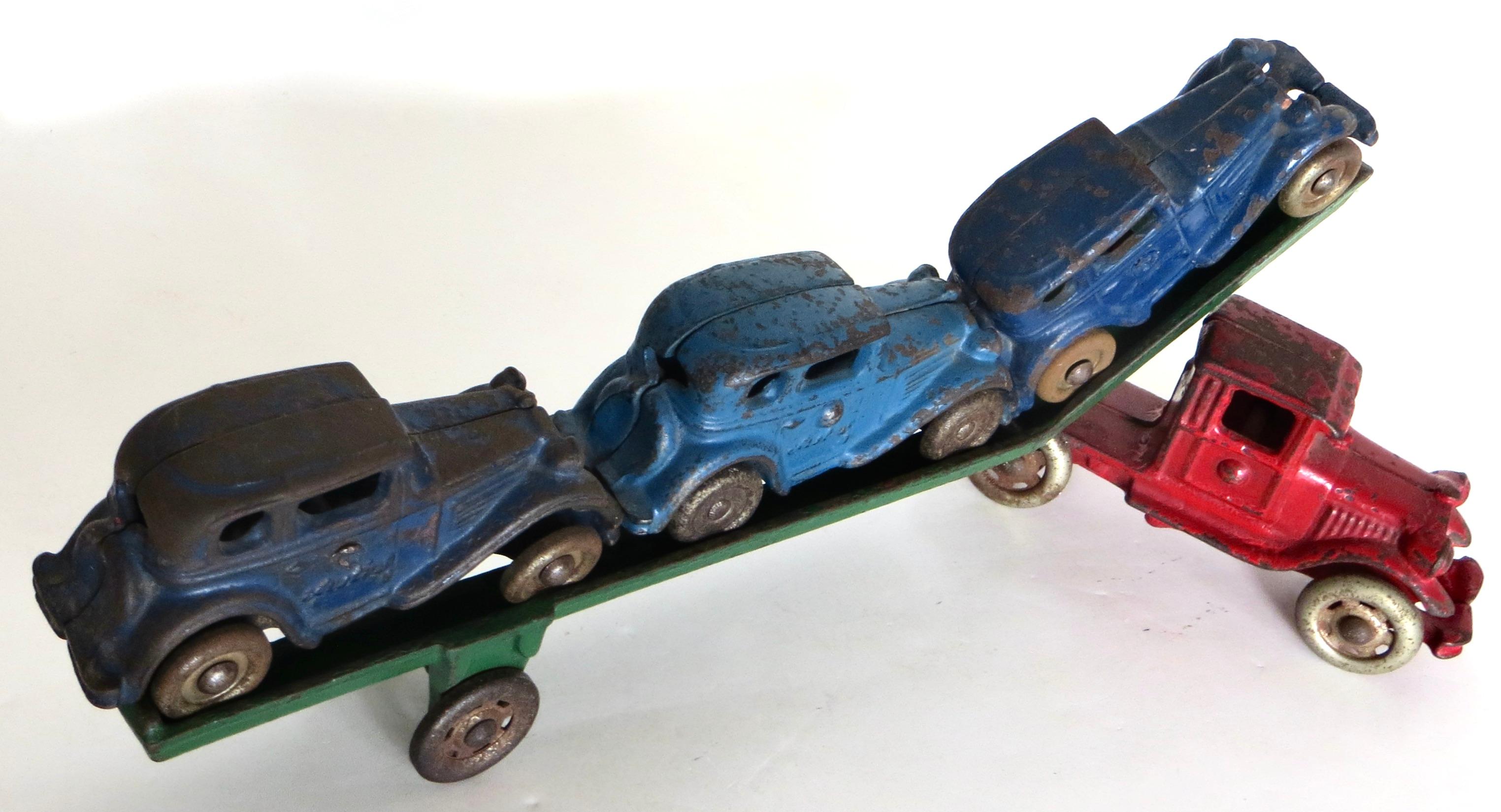 Founded in 1886, the A.C. Williams Toy Company in Ravenna, Ohio, manufactured this toy circa 1930. This cast iron truck car carrier loaded with three blue 