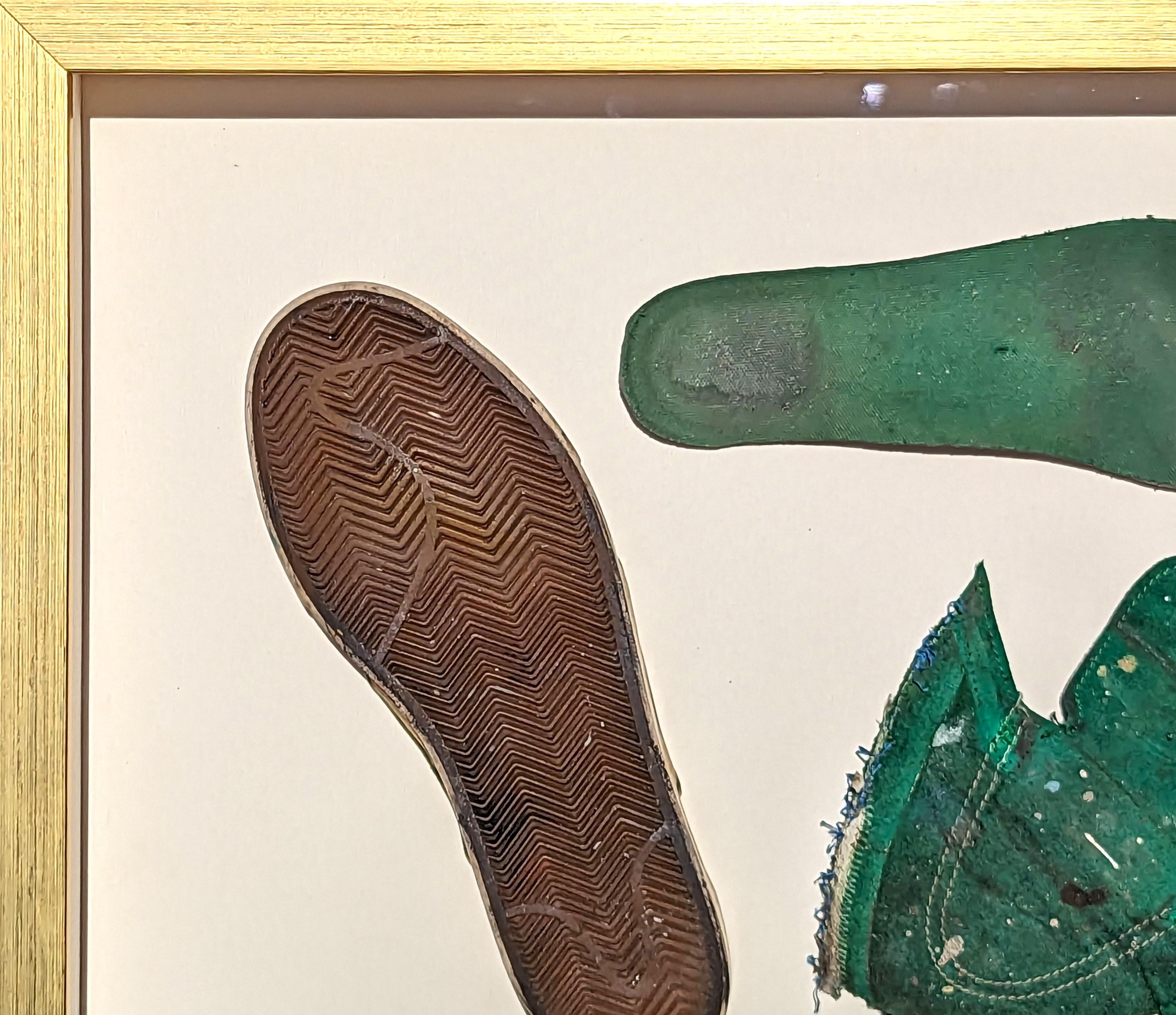 Zeitgenössische Fundstückmalerei der Künstlerin Tra' Slaughter aus Houston, TX. Das Werk zeigt einen grünen dekonstruierten Schuh, der in einem goldenen Rahmen schwebt. Diese Arbeit war Teil von Tra's Einzelausstellung 