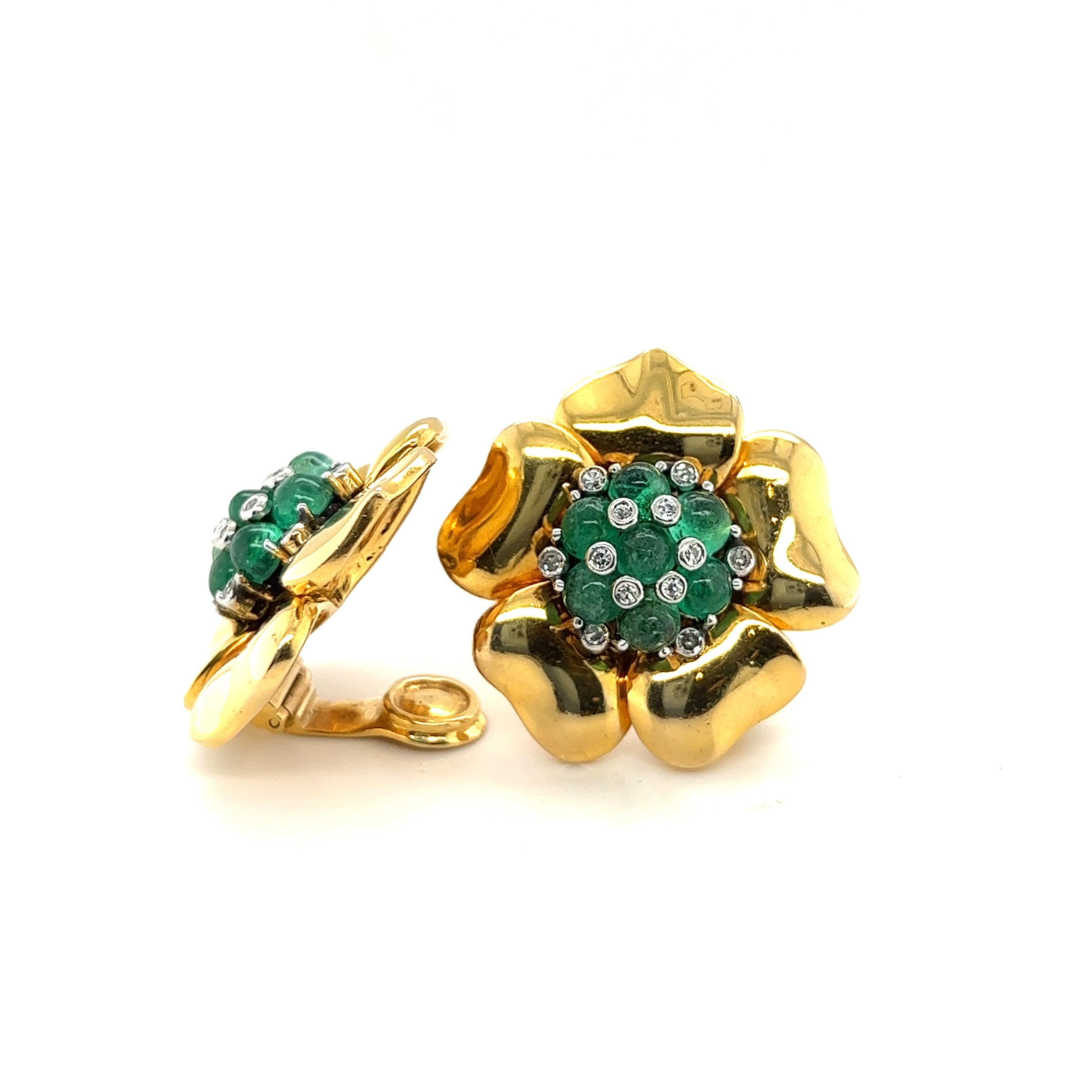 Gorgeous pair of Trabert & Hoeffer Mauboussin 14 karat yellow gold, emerald and diamond retro earclips, circa 1940s.
Each designed as a flower centering upon a cluster of emerald cabochons and single cut diamonds. The petals are crafted in 14 karat