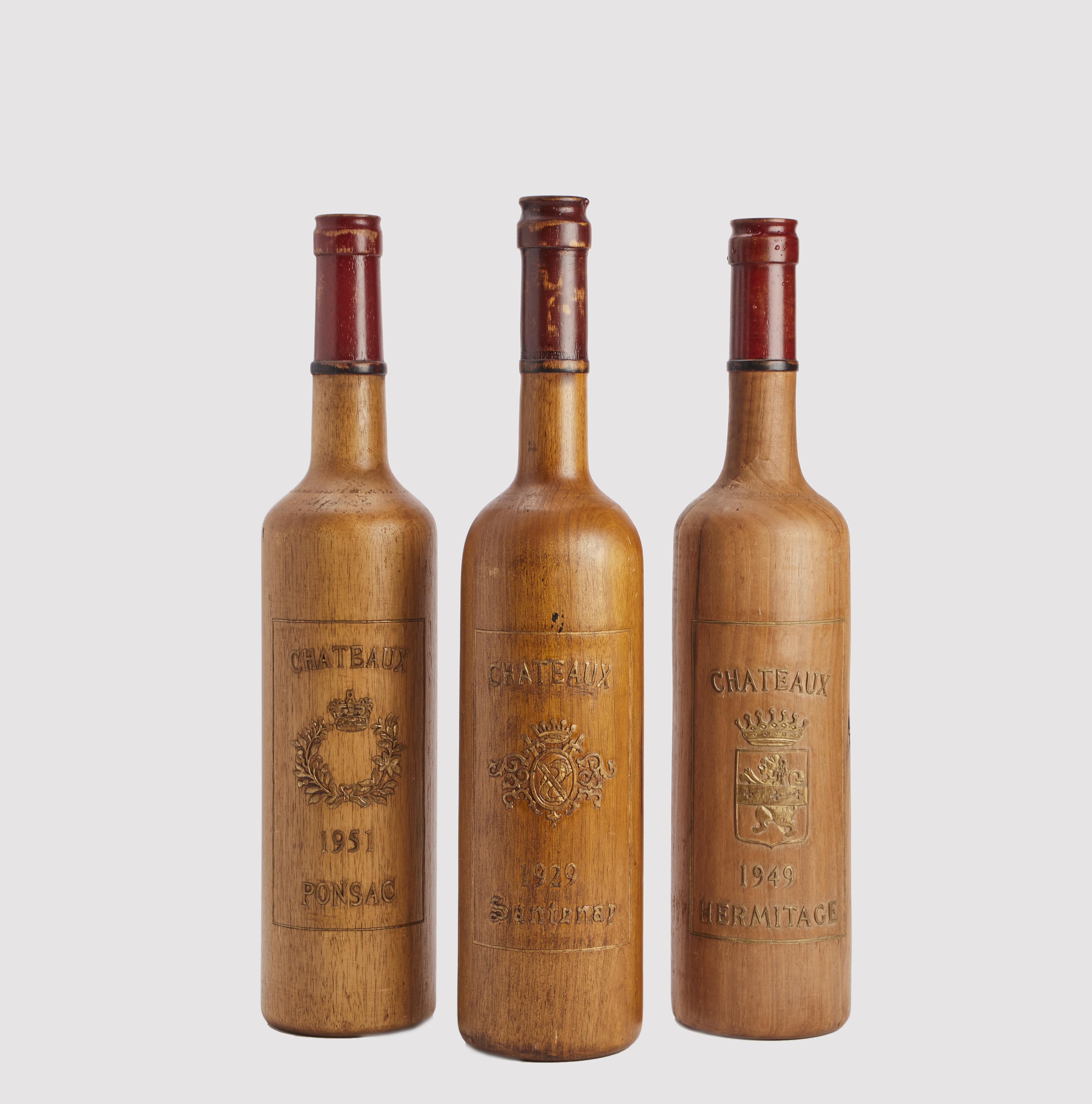 A trade sign for the window of a wine shop, depicting three bottles with the label of French wines: Chateau Santenay, Chateau Ponsac, Chateau Ermitage. Made of carved solid fruitwood. The labels are engraved in relief and finished in gold colour.