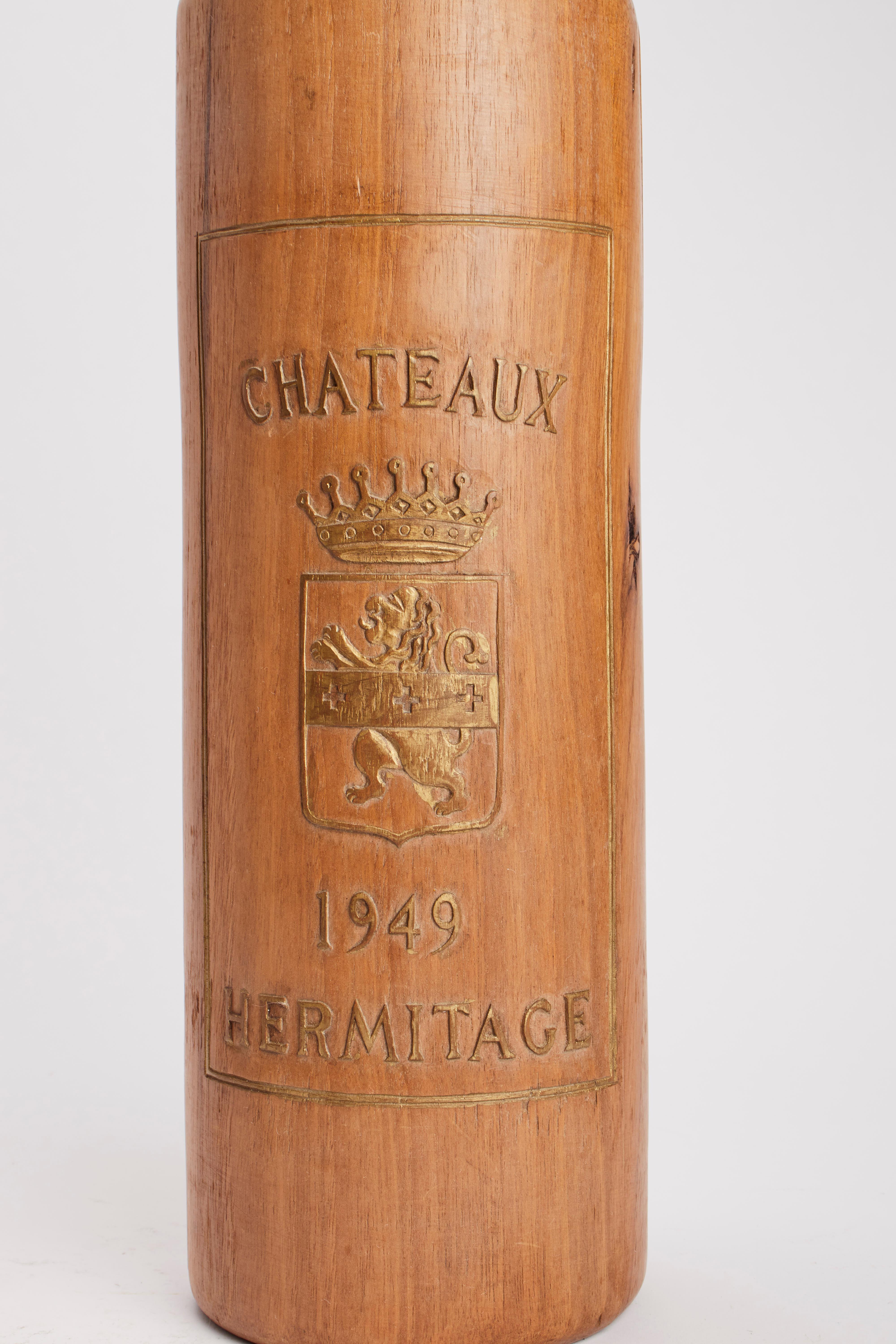 A trade sign for the window of a wine shop, depicting three bottles with the label of French wines: Chateau Santenay, Chateau Ponsac, Chateau Ermitage. Made of carved solid fruit wood. The labels are engraved in relief and finished in gold colour.