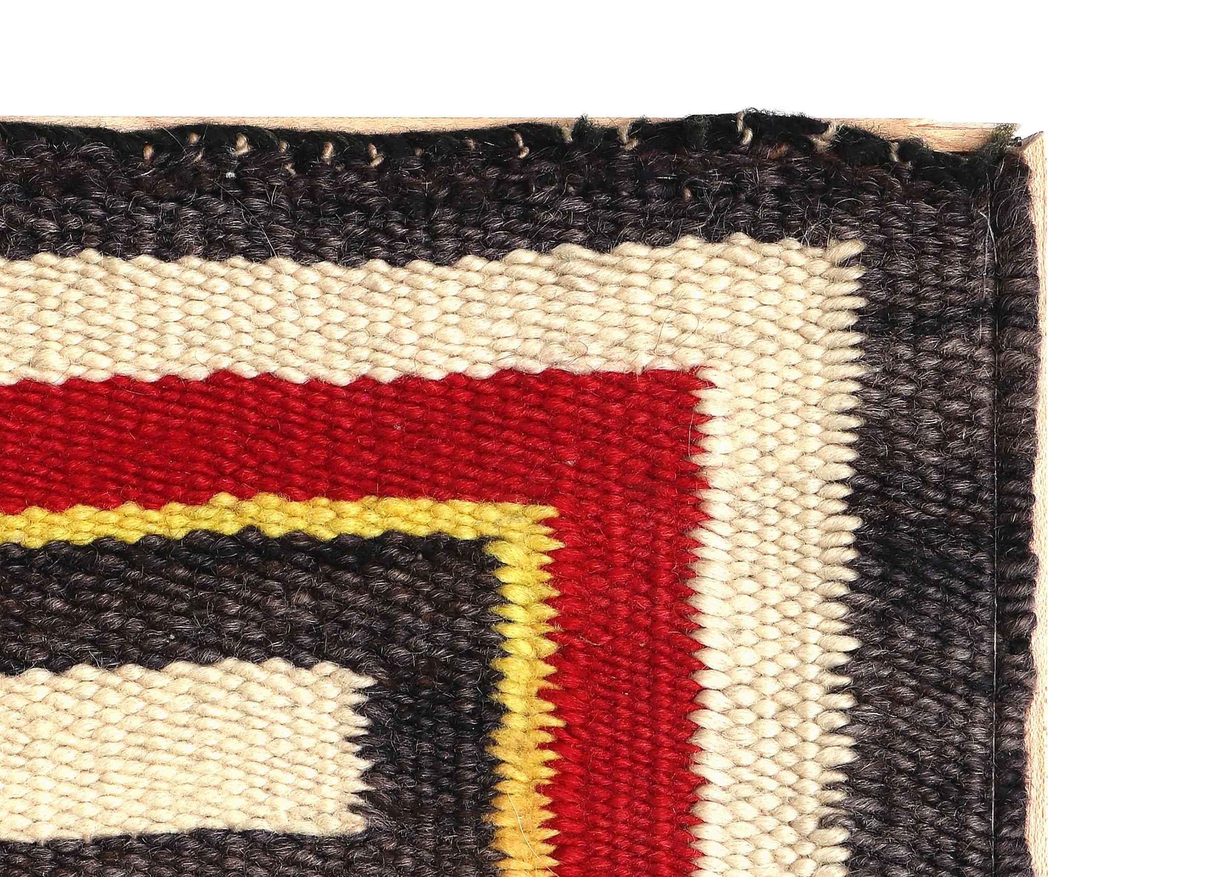 Mounted circa 1940s Navajo Weaving from the Trading Post Era. Seen is a stylized border with four airplane like central images and various male torsos with hats. Woven of native hand spun wool in colors of reds, yellows, blues, dark brown/black,