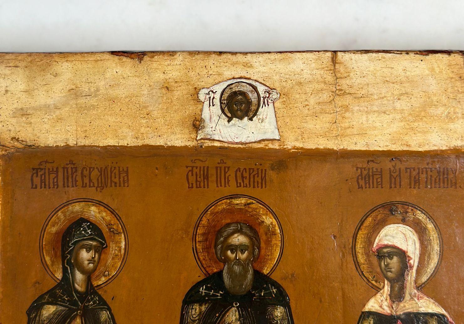 A traditional Russian icon made in the 18th century, depicting three saints and Lord Sabaoth protecting them from atop, shown with a mandala around his head, symbolizing his heavenly and divine presence.
The saints appear to be standing gracefully,