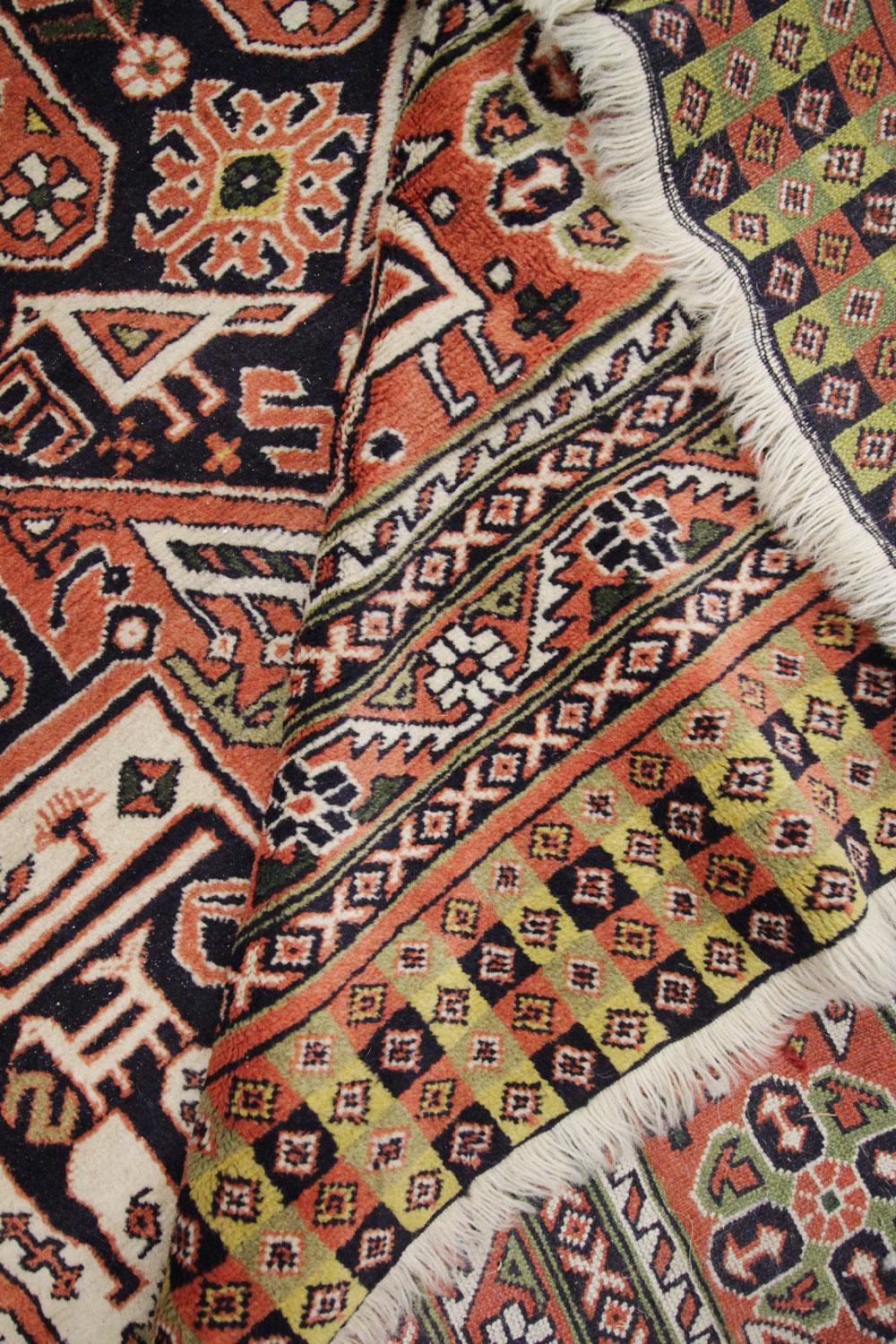 Ce tapis du milieu du siècle, fabriqué à la main, est de grande qualité et présente un motif géométrique tissé de manière complexe. Avec une palette de couleurs polyvalente composée d'un orange profond et de tons bleus profonds contrastés, ce tapis