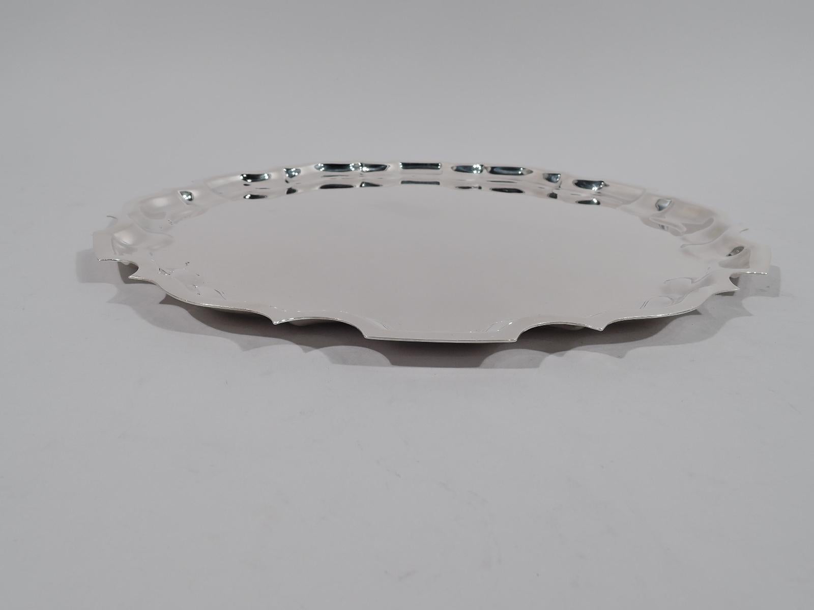 Traditional Georgian sterling silver tray. Made by Graff, Washbourne & Dunn in New York, circa 1920. Round with curvilinear piecrust rim. Fully marked and numbered G63. Heavy weight: 22.5 troy ounces.