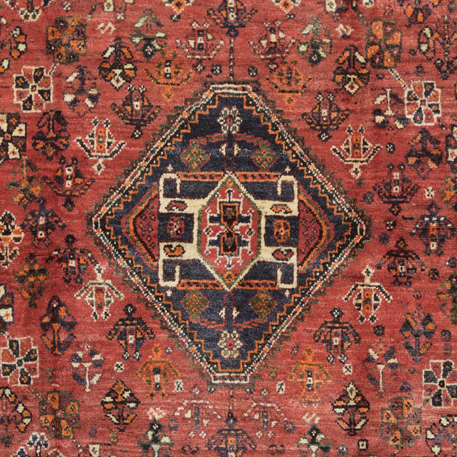 Measuring 5’3” x 8’8”, this Persian Ghashghai carpet is hand-knotted and belongs to Orley Shabahang’s World Market Collection. Woven in Iran in stunning hues of red, blue, orange, and green, this hand-knotted carpet utilizes a traditional Persian