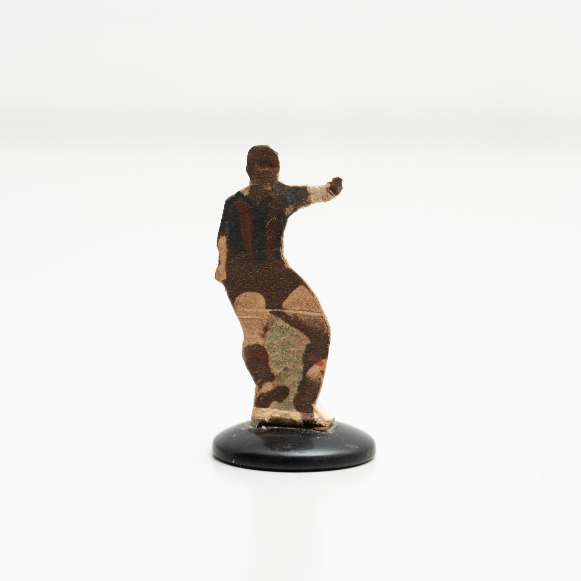 Table button soccer game player. Traditional figure used to play this classic button Spanish game. The figure is usually made by attaching a football player photograph, or sometimes a drawing, attached to a clothing button.

Manufactured in Spain,
