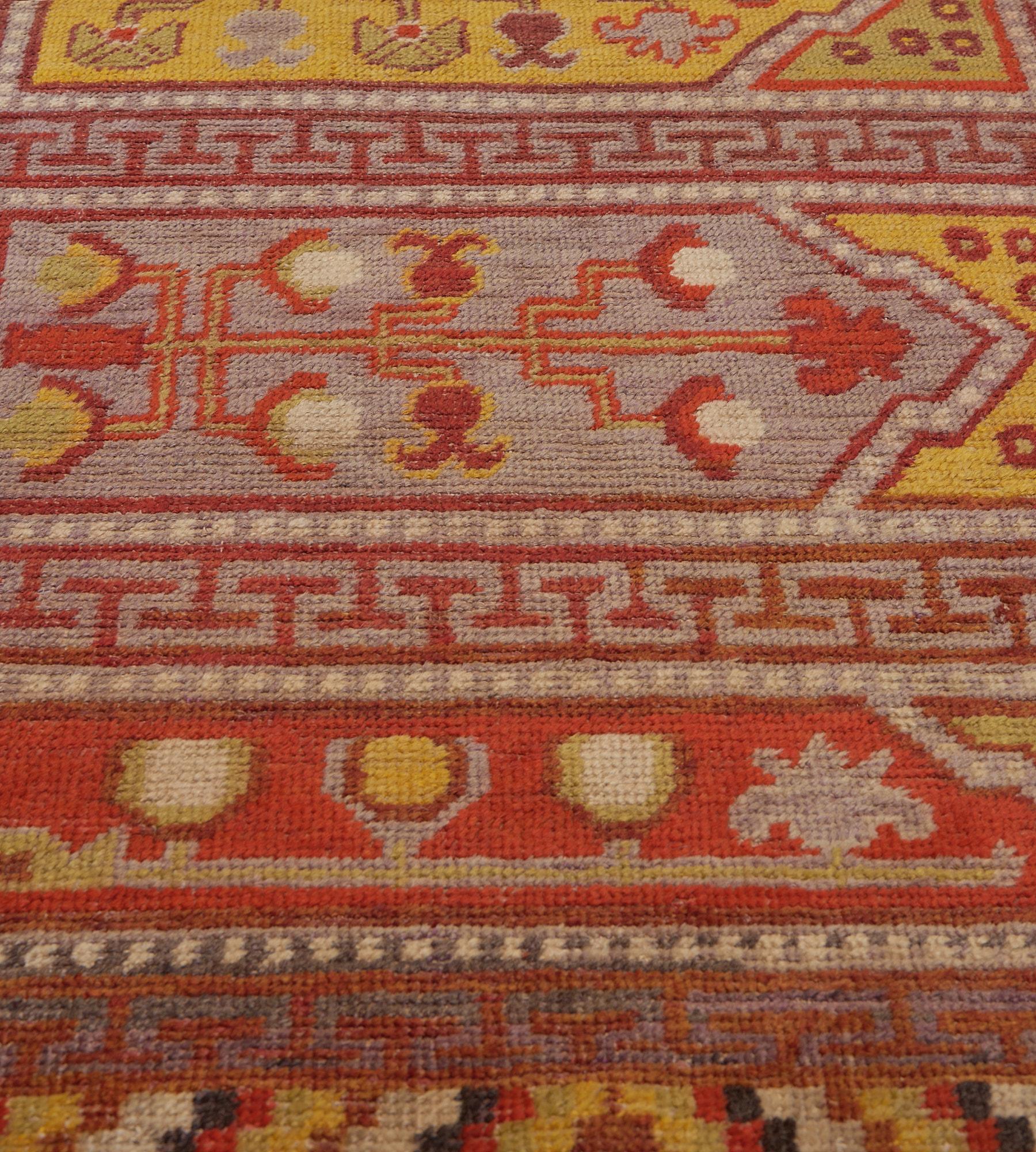 This antique, circa 1890, Khotan runner features a field with horizontal polychrome panels each with a vase issuing various fruits and floral motifs, the arched panels above with small flowerheads, each panel surrounded by a narrow dot-motif band