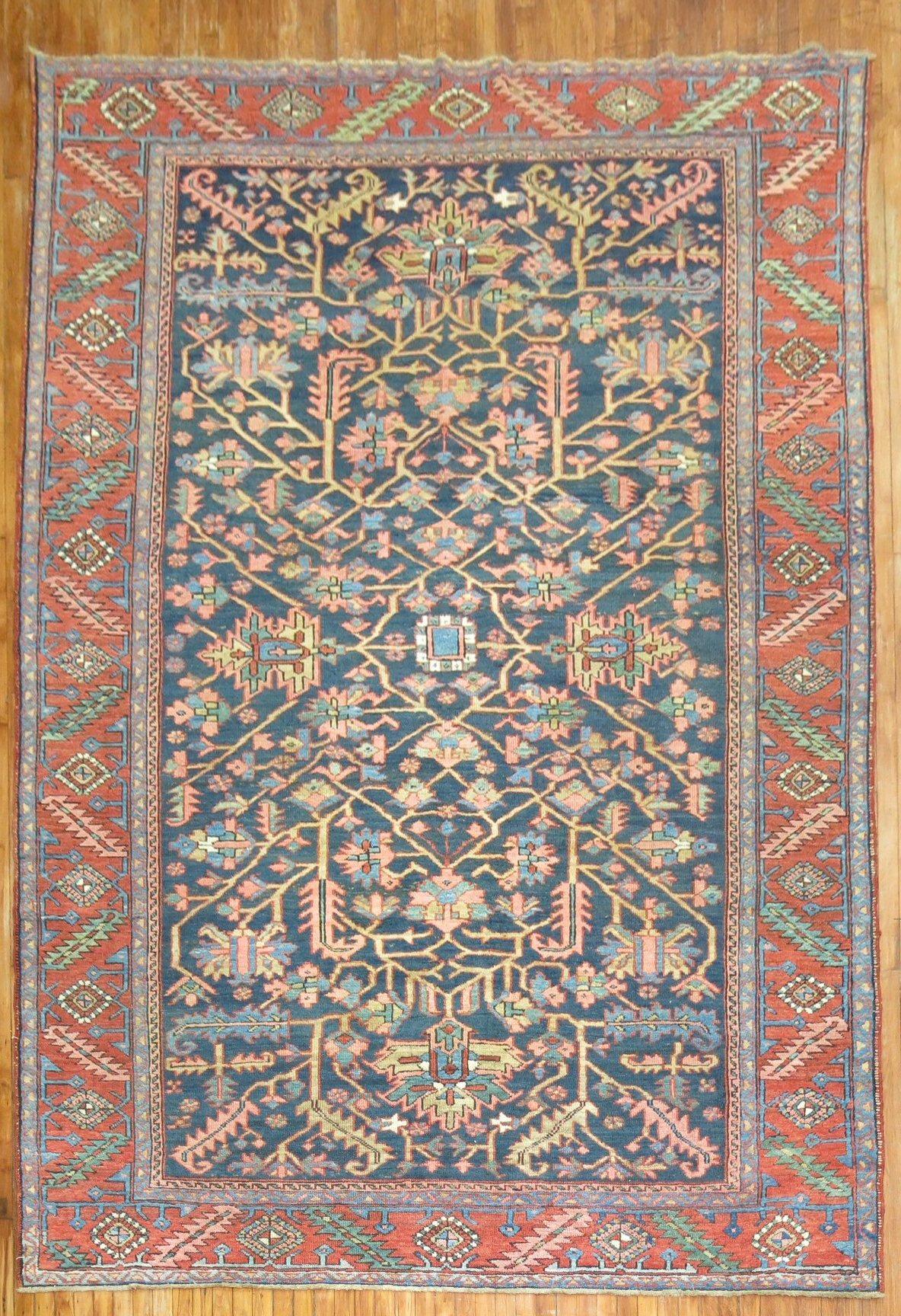 Tapis persan Heriz traditionnel du début du XXe siècle, à fond bleu marine et à motifs tribaux.

Mesures : 8'2'' x 11'8