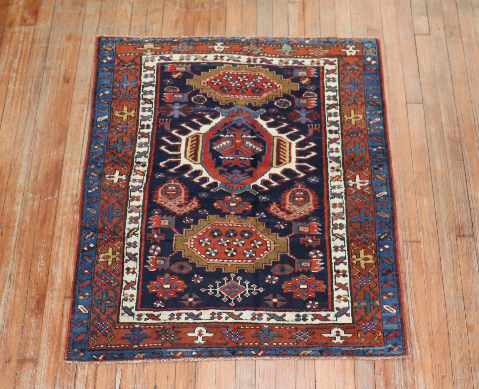 An early 20th century traditional navy blue and brown square size Persian Heriz carpet.

Measures: 3'4