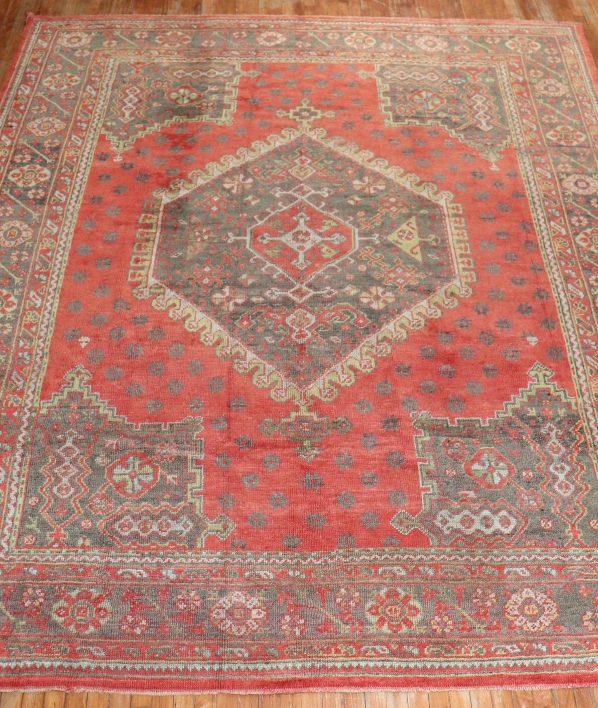 An early 20th century Turkish Oushak with a traditional medallion and border motif on a red field. The border and medallion are gray

Measures: 9'2