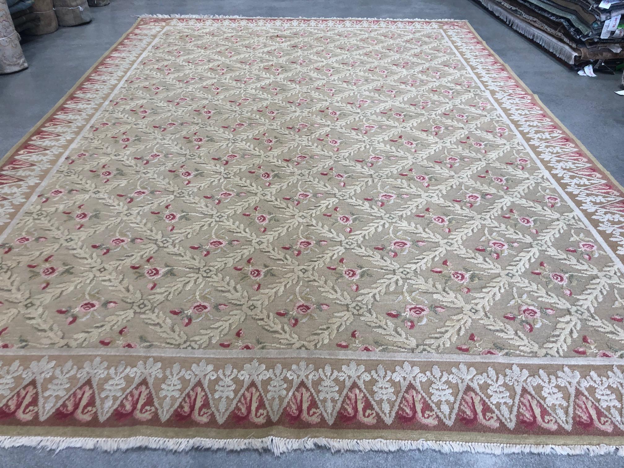 A trellis of pink and red roses is framed by a brown and silver border in a rug reminiscent of the administer style of woven carpets. Wool.