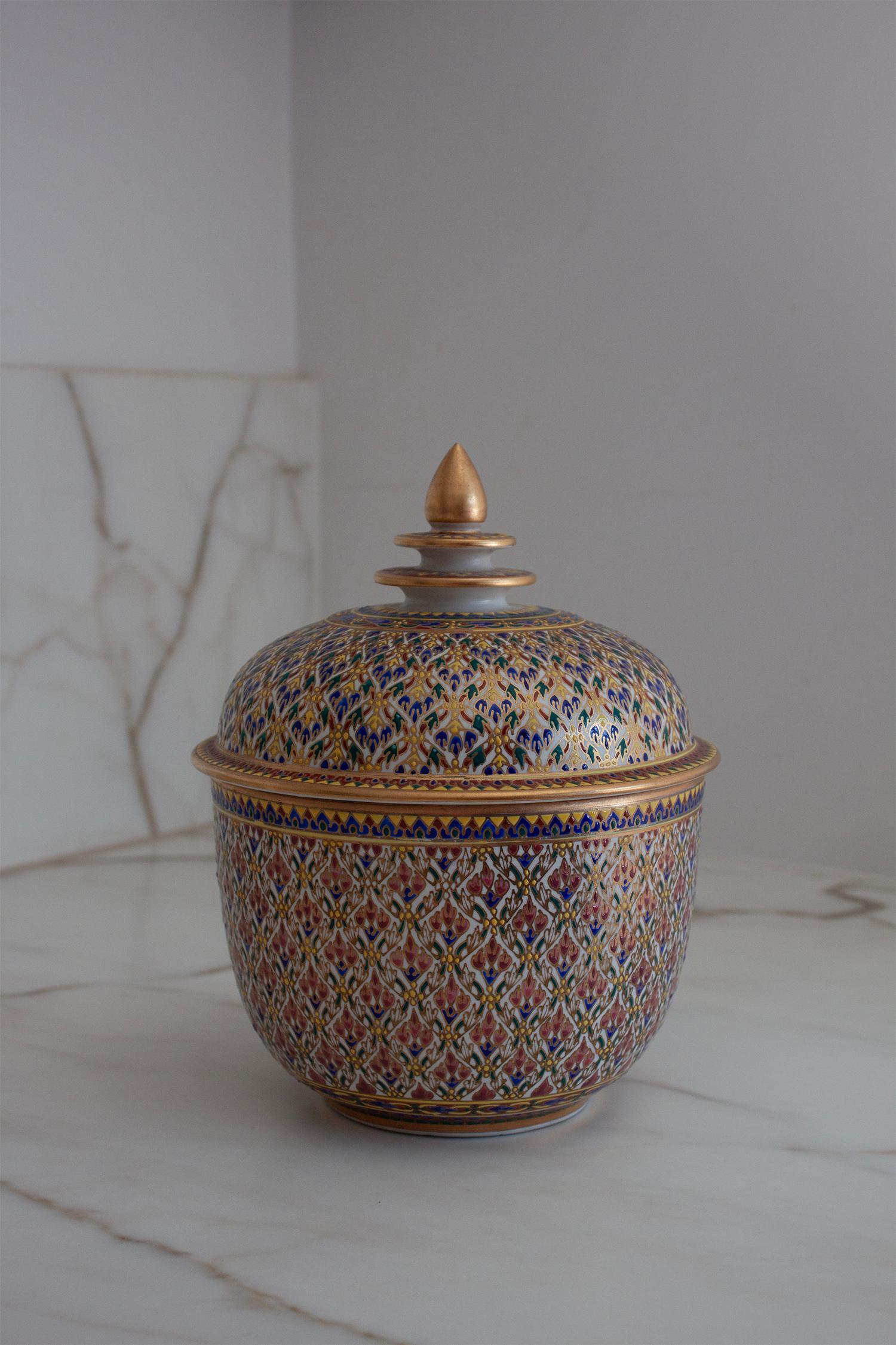 Dieses farbenfrohe thailändische Bencharong-Gefäß ist ein wunderschönes Beispiel für traditionelle Handwerkskunst. Es zeigt aufwändige, handgemalte Blumenmotive in leuchtenden Rot-, Blau-, Grün-, Gelb- und Goldtönen. Die aus der königlichen