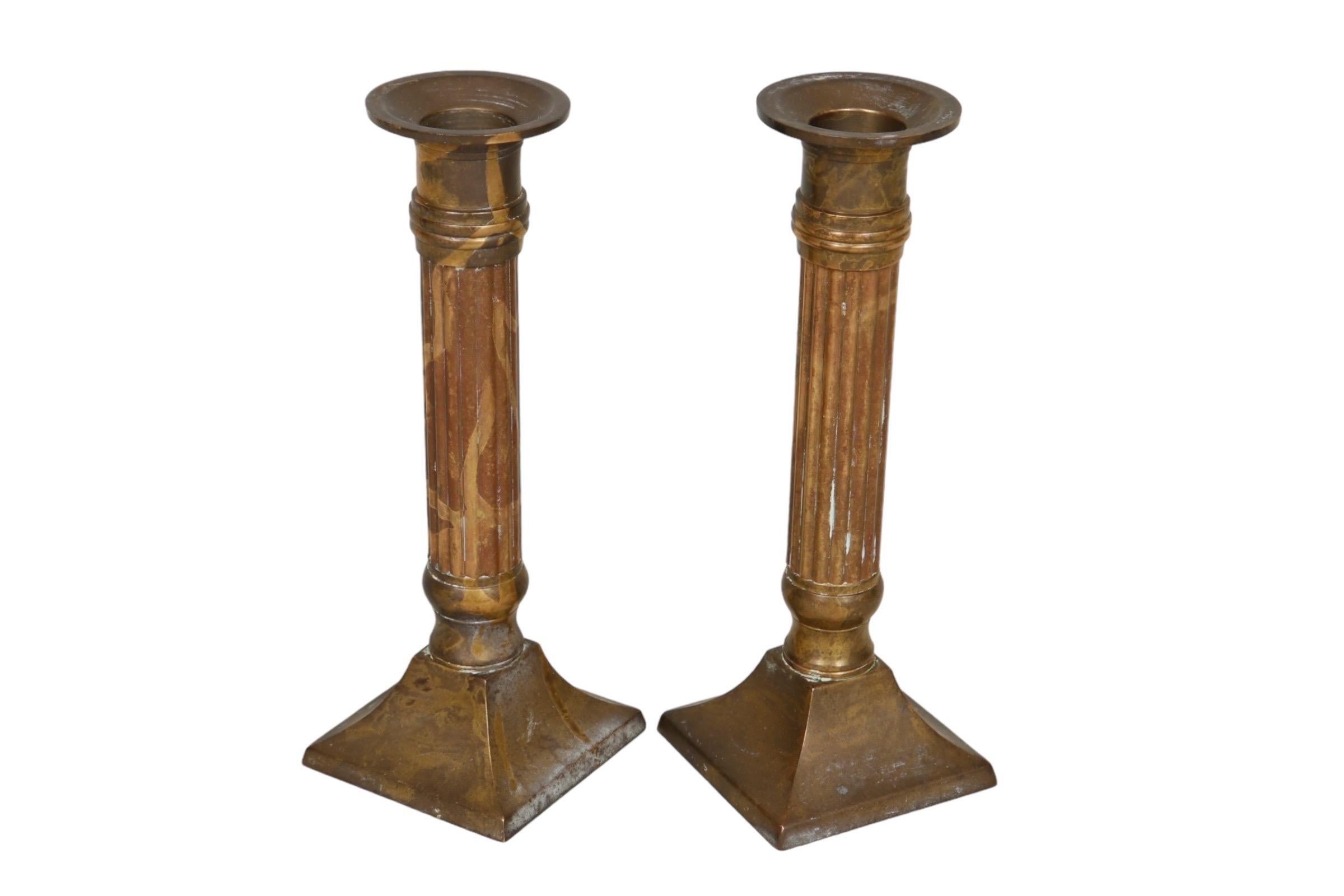 Una coppia di portacandele tradizionali in ottone. Semplici teglie di cera sormontano colonne dritte e lamellari su basi quadrate. L'ottone ha una ricca patina. Dimensioni per candeliere.

Abbiamo altri candelieri disponibili. Dai un'occhiata ai