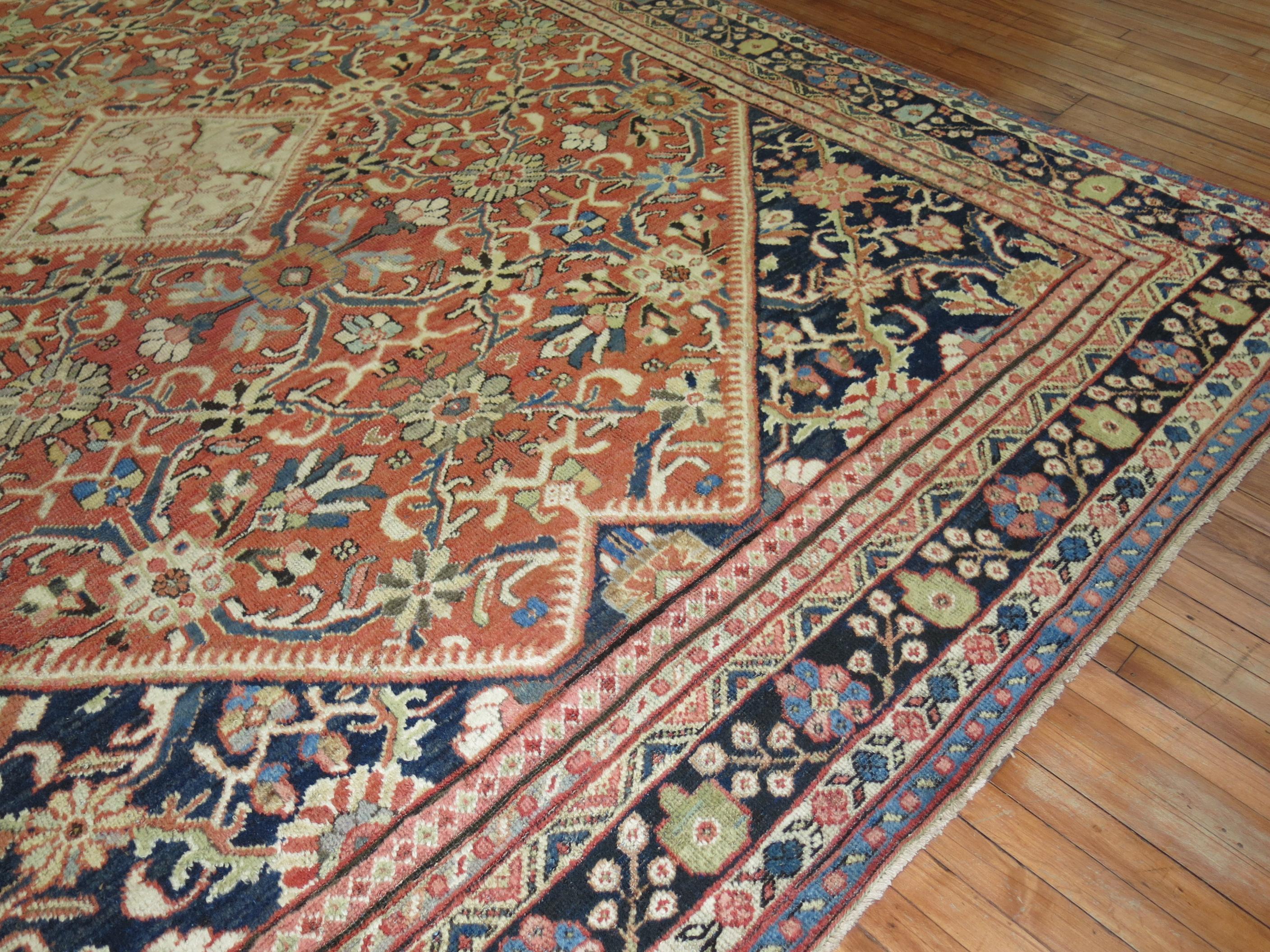 Room size early 20th century antique Persian Mahal rug with a traditional medallion, 4 corner, border design in rust, brick navy, and antique white.

Measures: 9'8” x 12'3