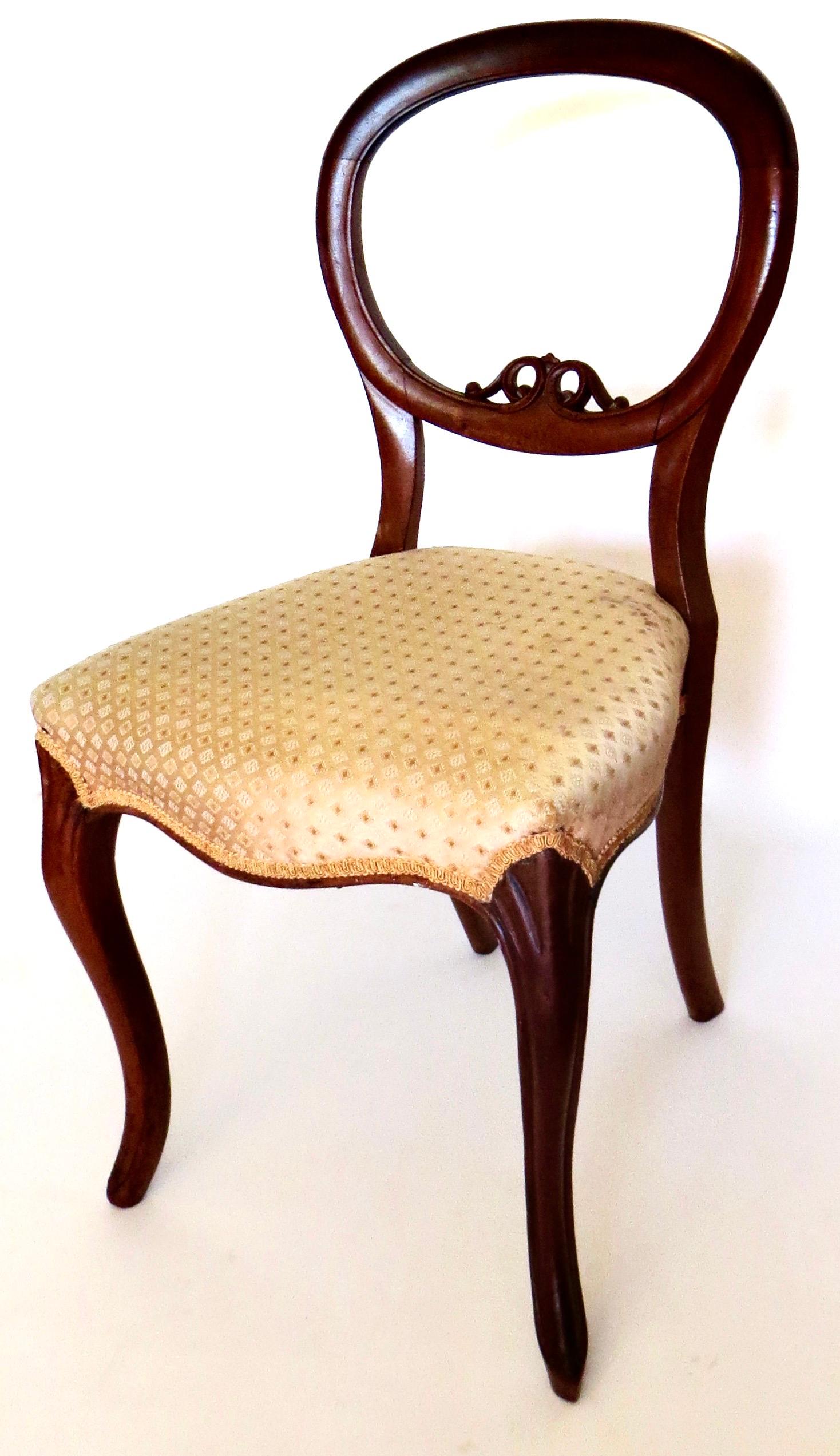 Typical English Balloon Back Chair used for the parlor, a lady's desk, or in the boudoire at a dressing table in mid-Victorian England. It has the round, or balloon shaped back; cabriole front legs with splayed rear legs; and a small crest to the