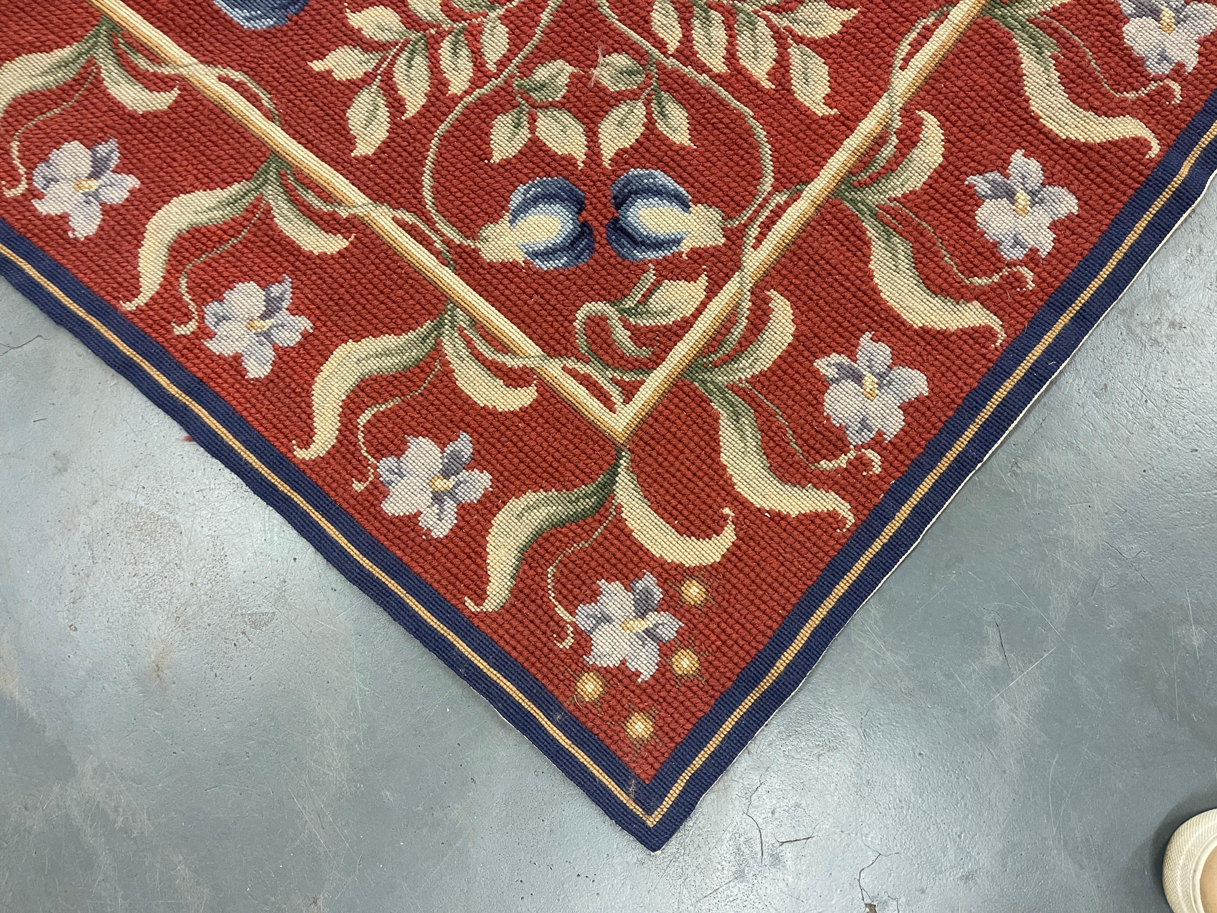 Dieser fantastische Teppich wurde von Hand gewebt und zeigt ein wunderschönes asymmetrisches Blumenmuster auf einem roten Hintergrund mit creme-grünen und elfenbeinfarbenen Akzenten. Die Farbe und das Design dieses eleganten Stücks machen ihn zu