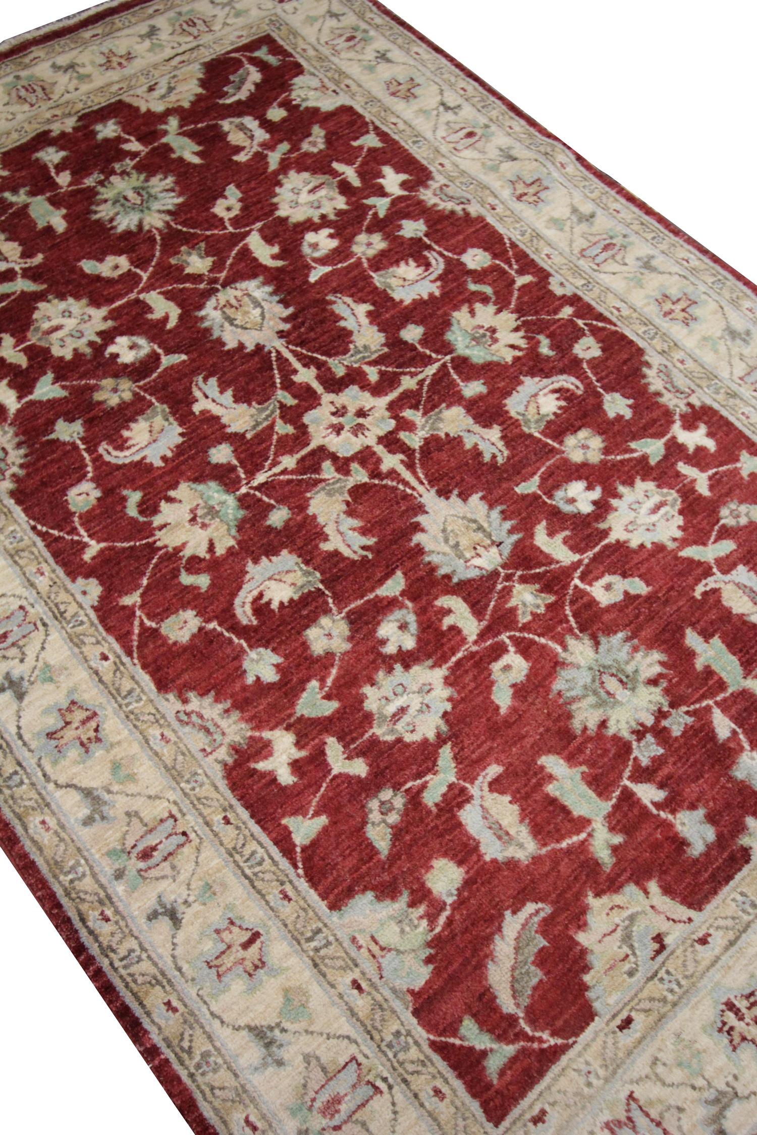 This rich red wool area rug is a fine example of the Ziegler design. Woven by hand in the early 21st century in Pakistan. The design has been woven with a traditional deep red background and cream accents that make up the decorative floral pattern