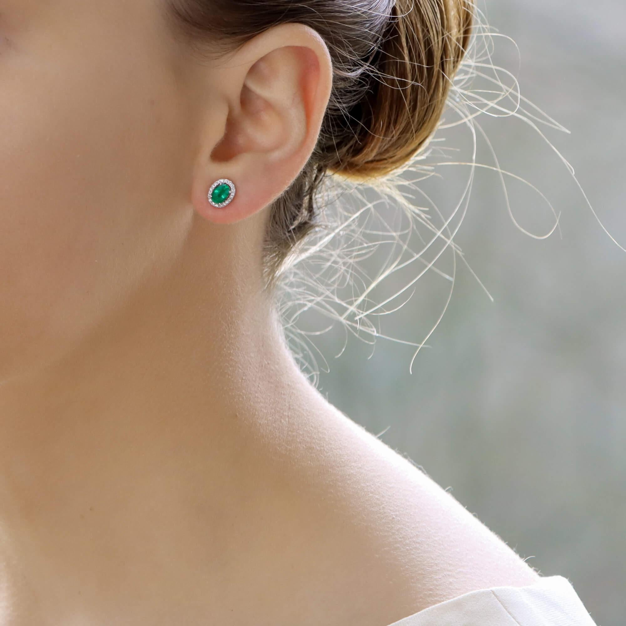 A fabulous pair of emerald and diamond ear studs set in 18k white gold. Each earring is centrally set with a beautiful oval cut emerald of a vibrant colour. The emerald is then surrounded by a halo of sparkling round brilliant cut diamonds.

Due to