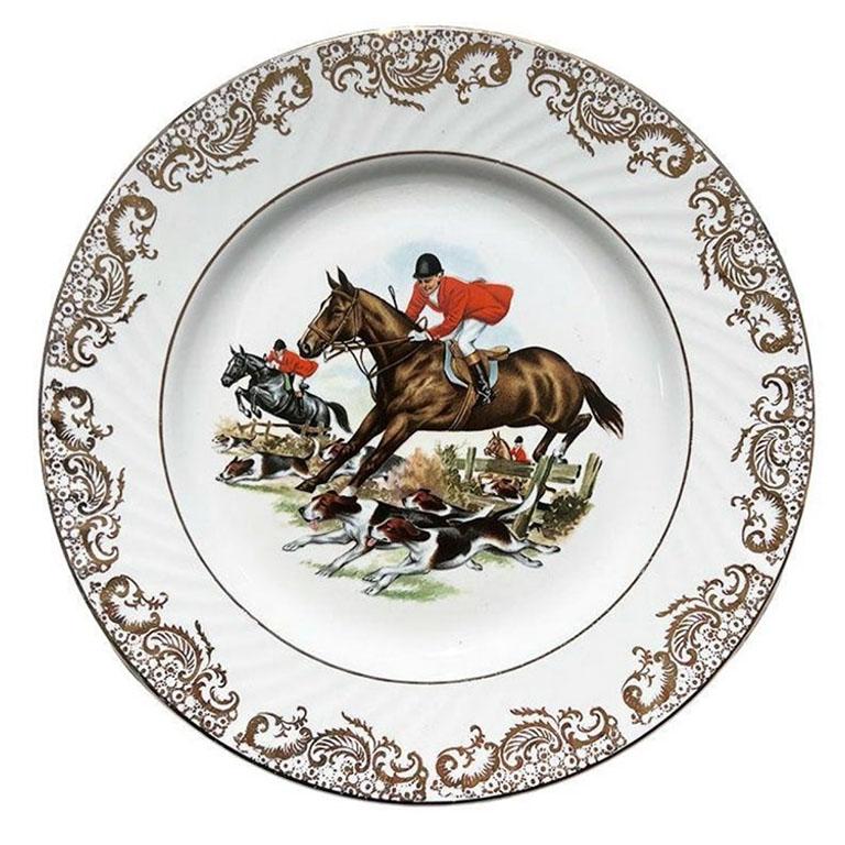 A traditional English hunting plate by Barratts of Staffordshire England. This round ceramic plate will be a fabulous accent to a gallery wall. It is glazed in a creamy white and features a traditional English fox hunt scene on the front. Three