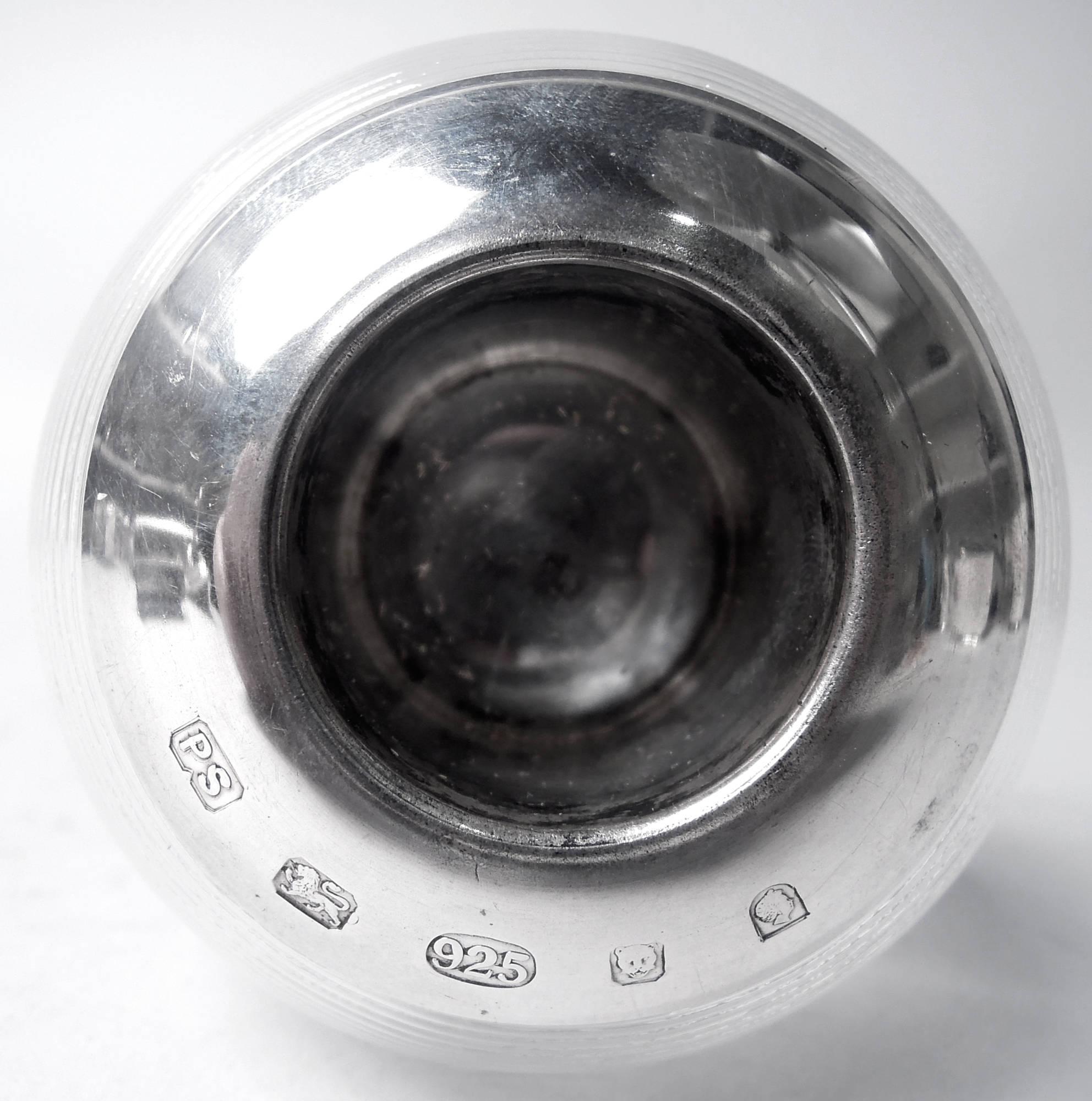 Colpo di fiammifero in cristallo di Elisabetta II con montatura in argento, 2002. Globulare con sottili nervature orizzontali. Il pozzo ha un collare piatto e semplice in argento sterling. Il cristallo è chiaro. I marchi includono il timbro del