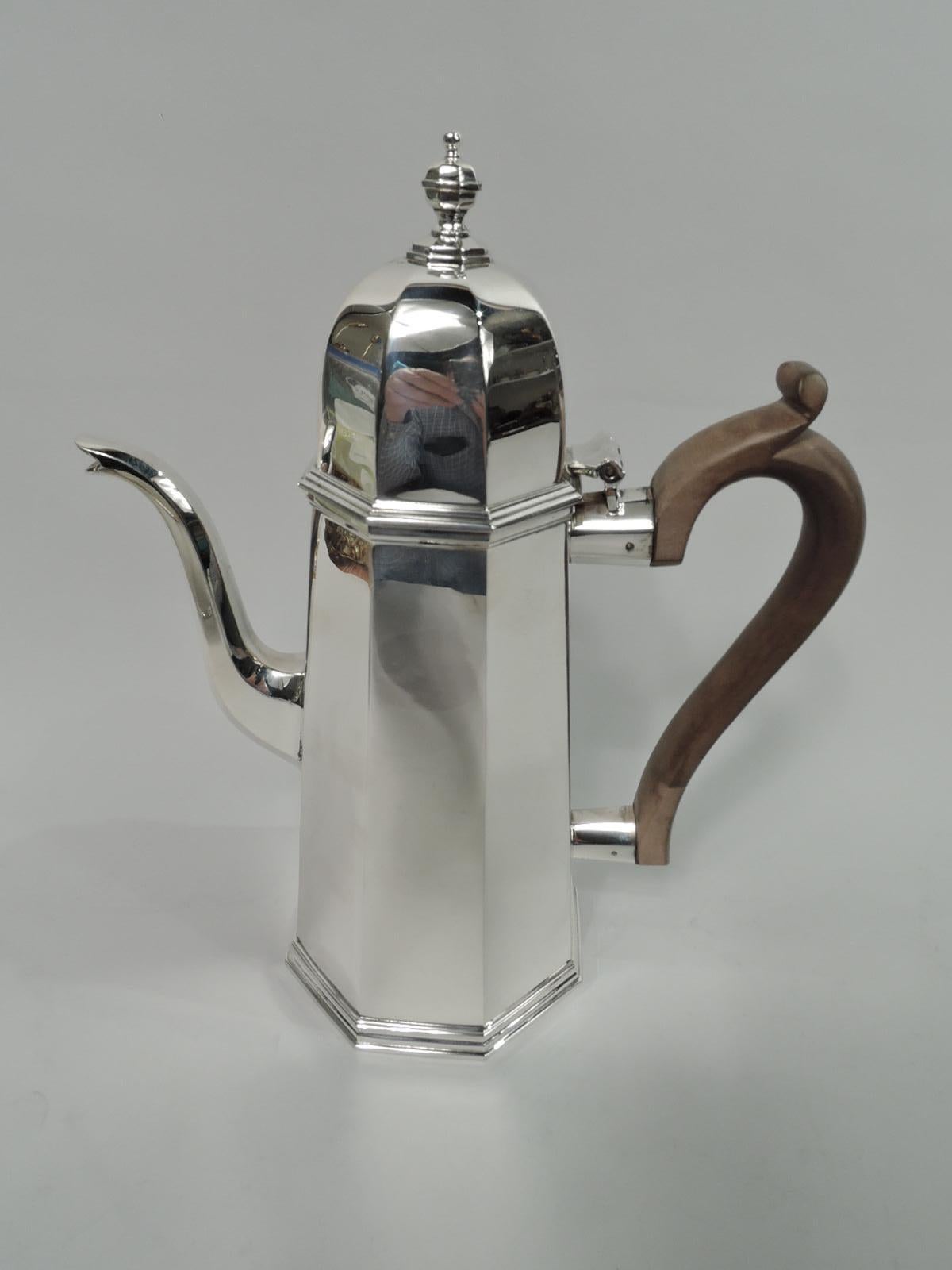 English Georgian sterling silver coffeepot and creamer, 1987. Coffeepot: Faceted octagonal body with upward and tapering sides, hinged and dome finial with vasiform finial, s-spout, and stained-wood capped scroll handle. Creamer: Faceted baluster on