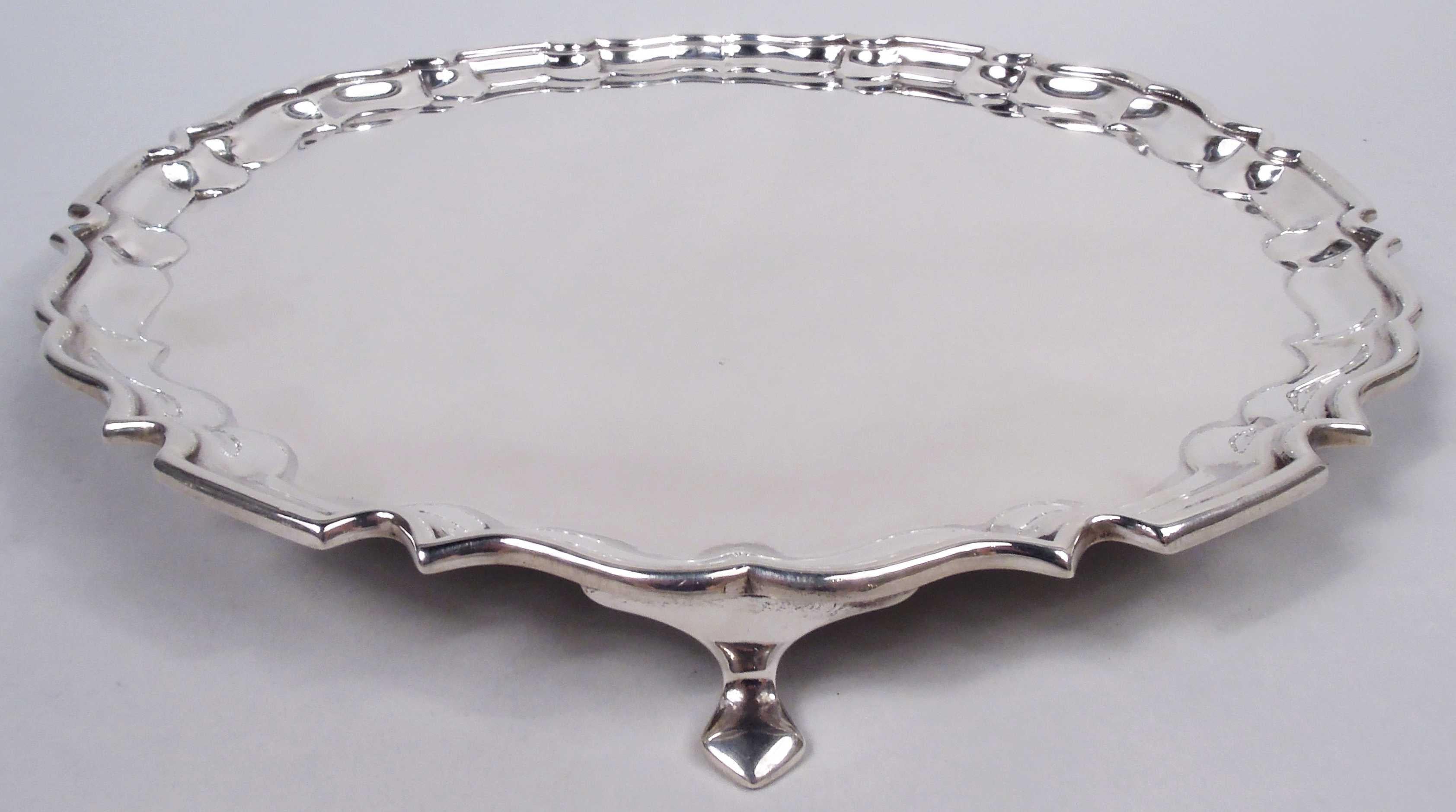 George V sterling silver salver. Made by Collingwood & Sons in Sheffield in 1937. Round with molded curvilinear piecrust rim; 3 hoof supports. Fully marked. Weight: 17 troy ounces.