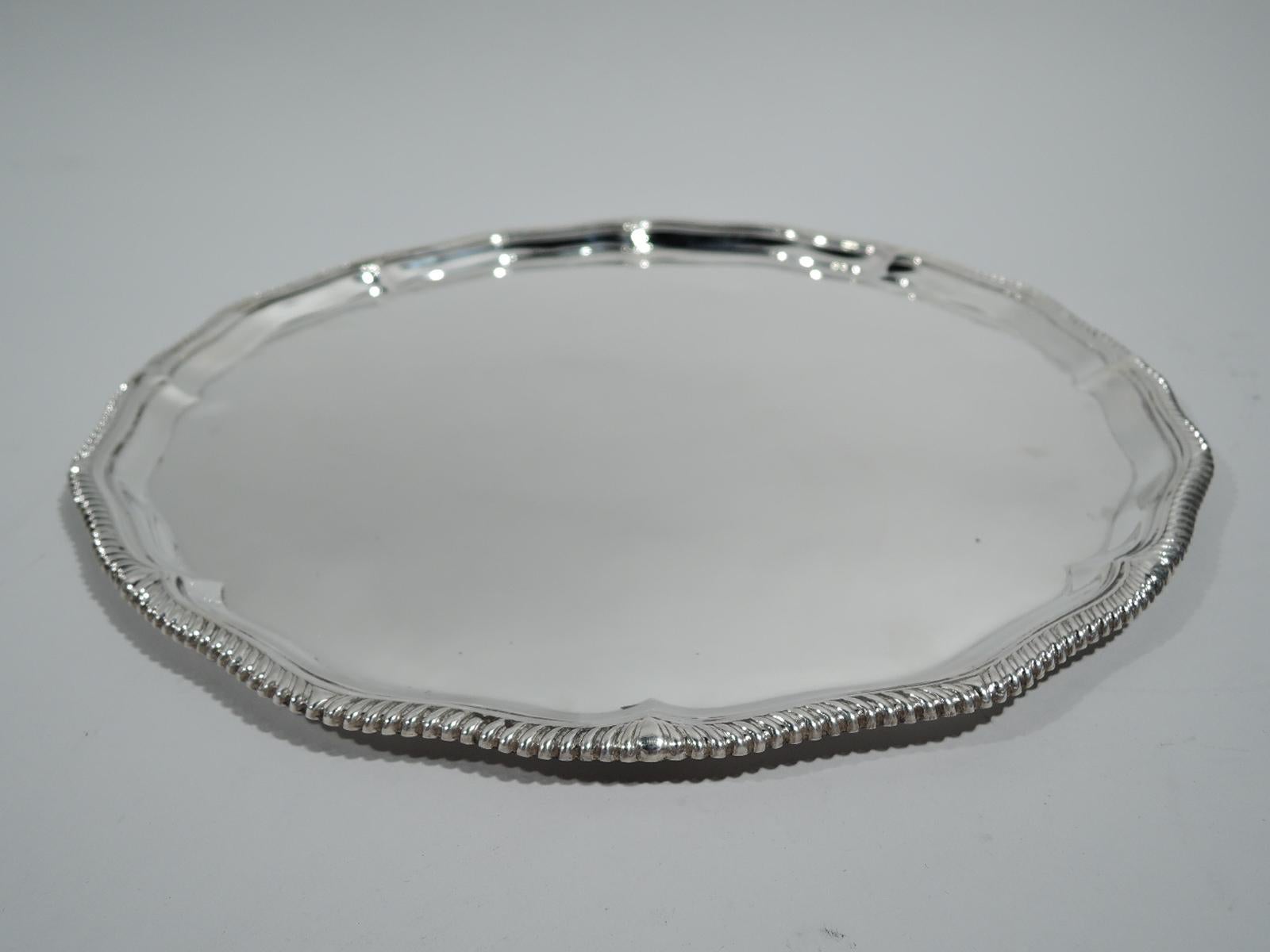 Elizabeth II sterling silver tray. Made by Adie Brothers in Birmingham in 1961. Round with gently scrolled and gadrooned rim. Traditional neoclassical style. Plenty of room for engraved presentation. Fully marked. Weight: 24 troy ounces.